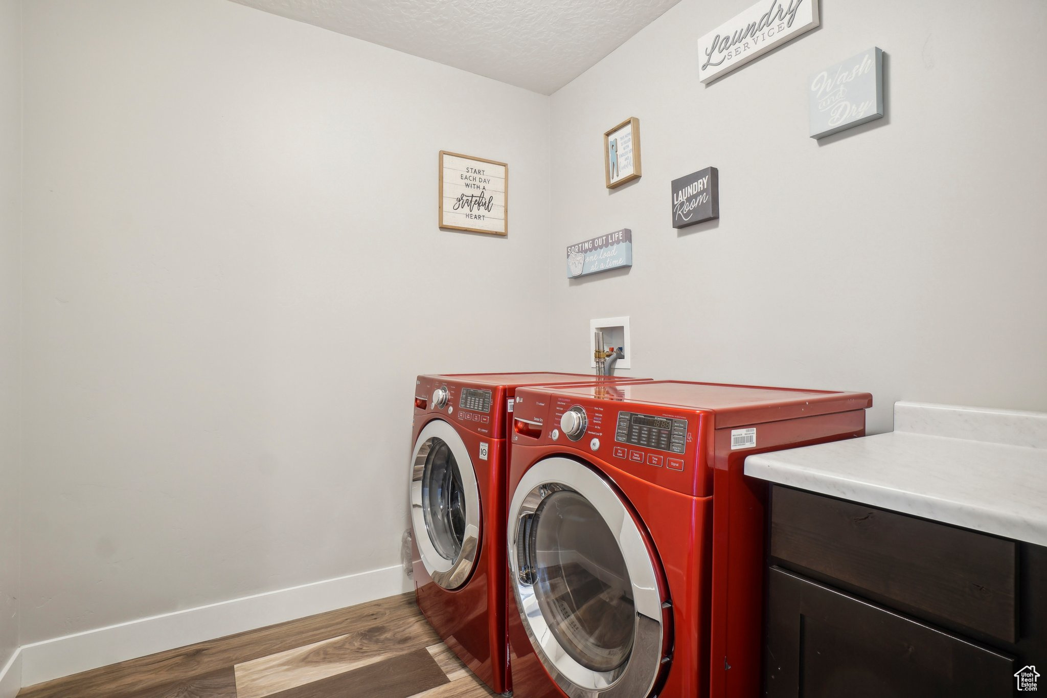 Laundry room featuring washing machine and dryer, washer hookup, a textured ceiling, and hardwood / wood-style floors