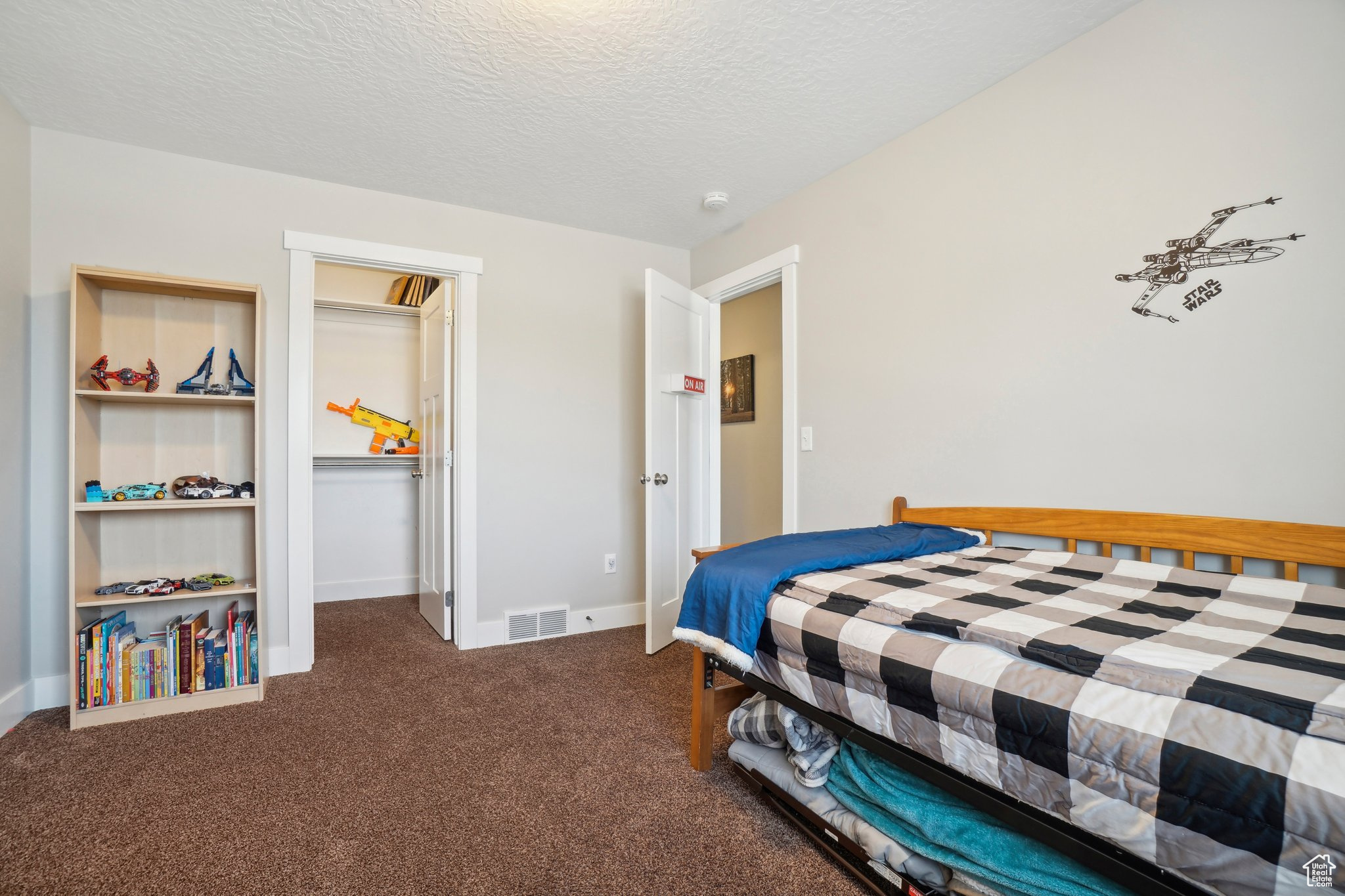 Carpeted bedroom featuring a textured ceiling