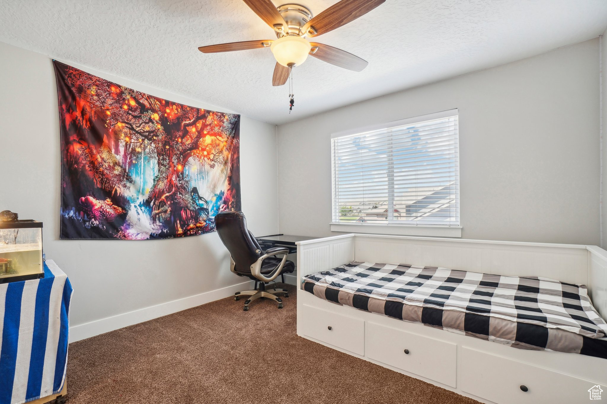 Bedroom featuring a textured ceiling, dark colored carpet, and ceiling fan