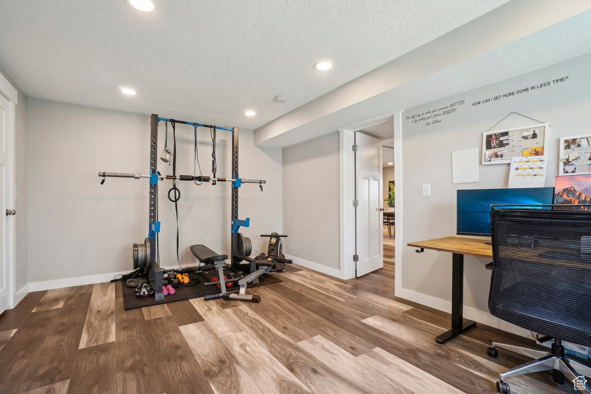 Exercise room with hardwood / wood-style floors and a textured ceiling