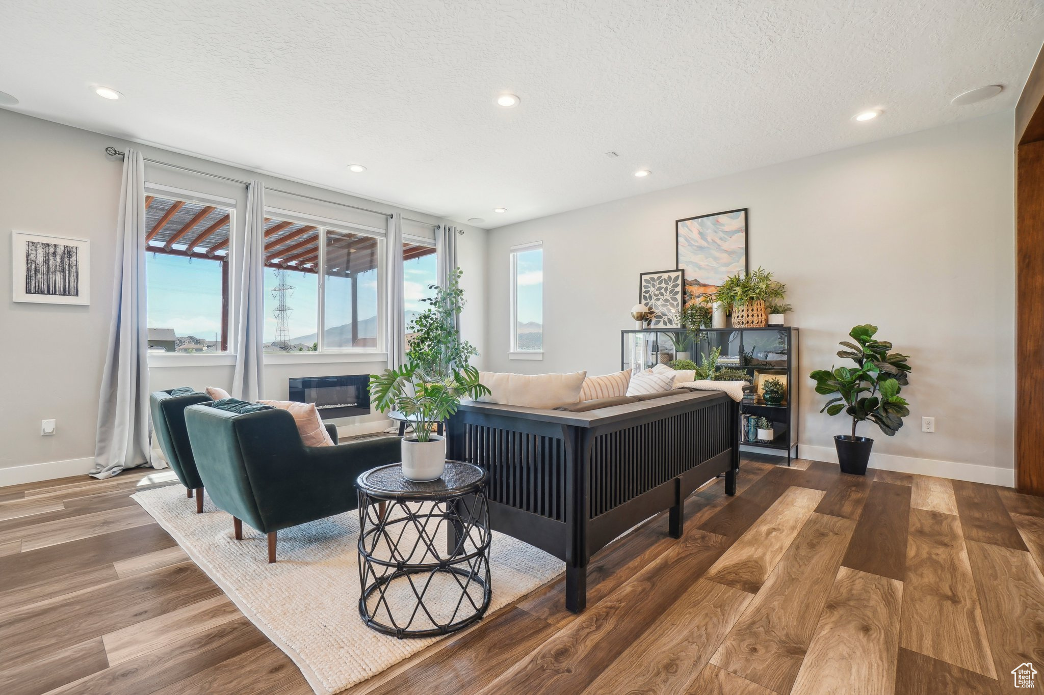 Living room featuring a textured ceiling, a healthy amount of sunlight, and hardwood / wood-style floors