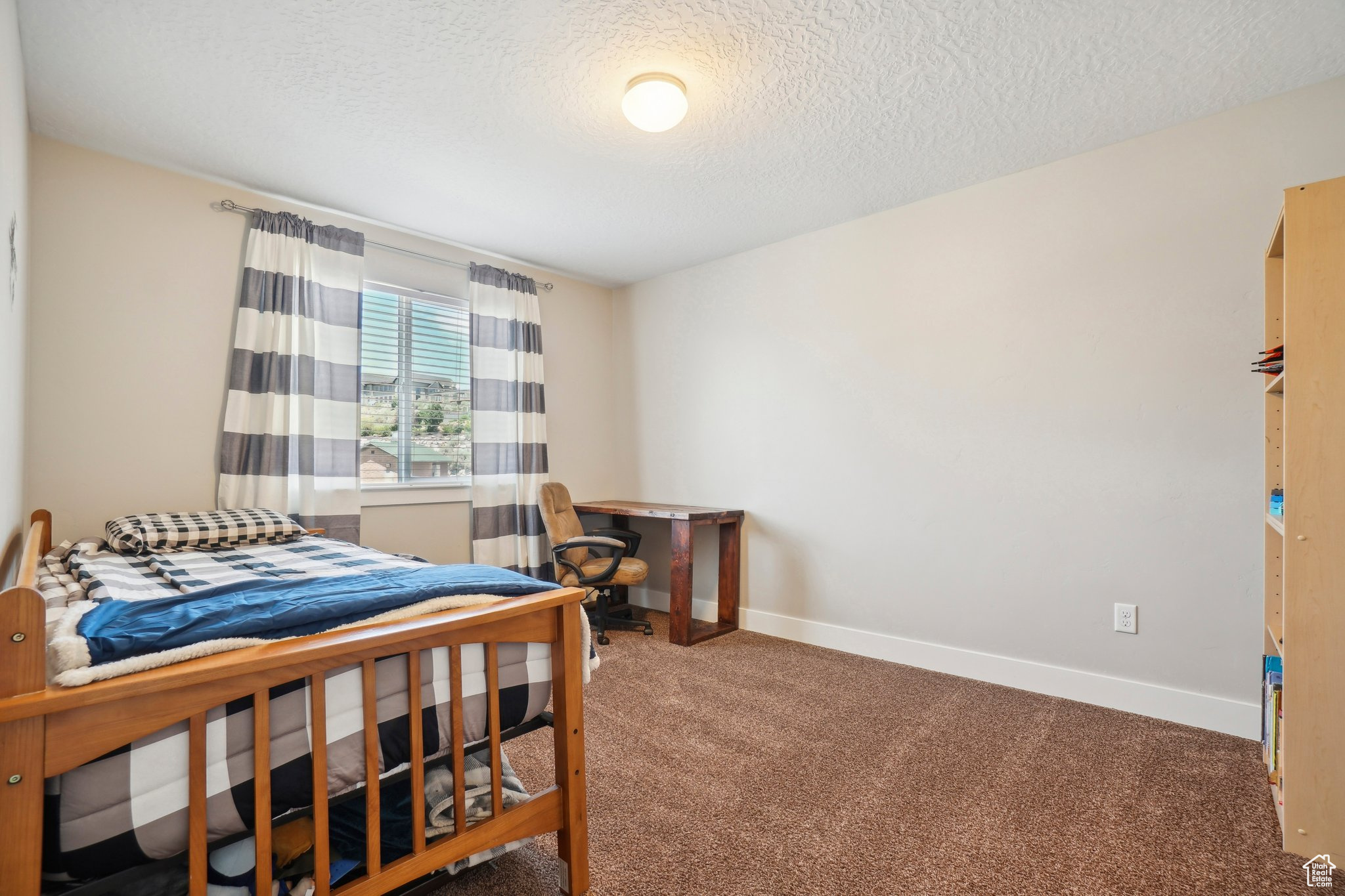 Carpeted bedroom with a textured ceiling