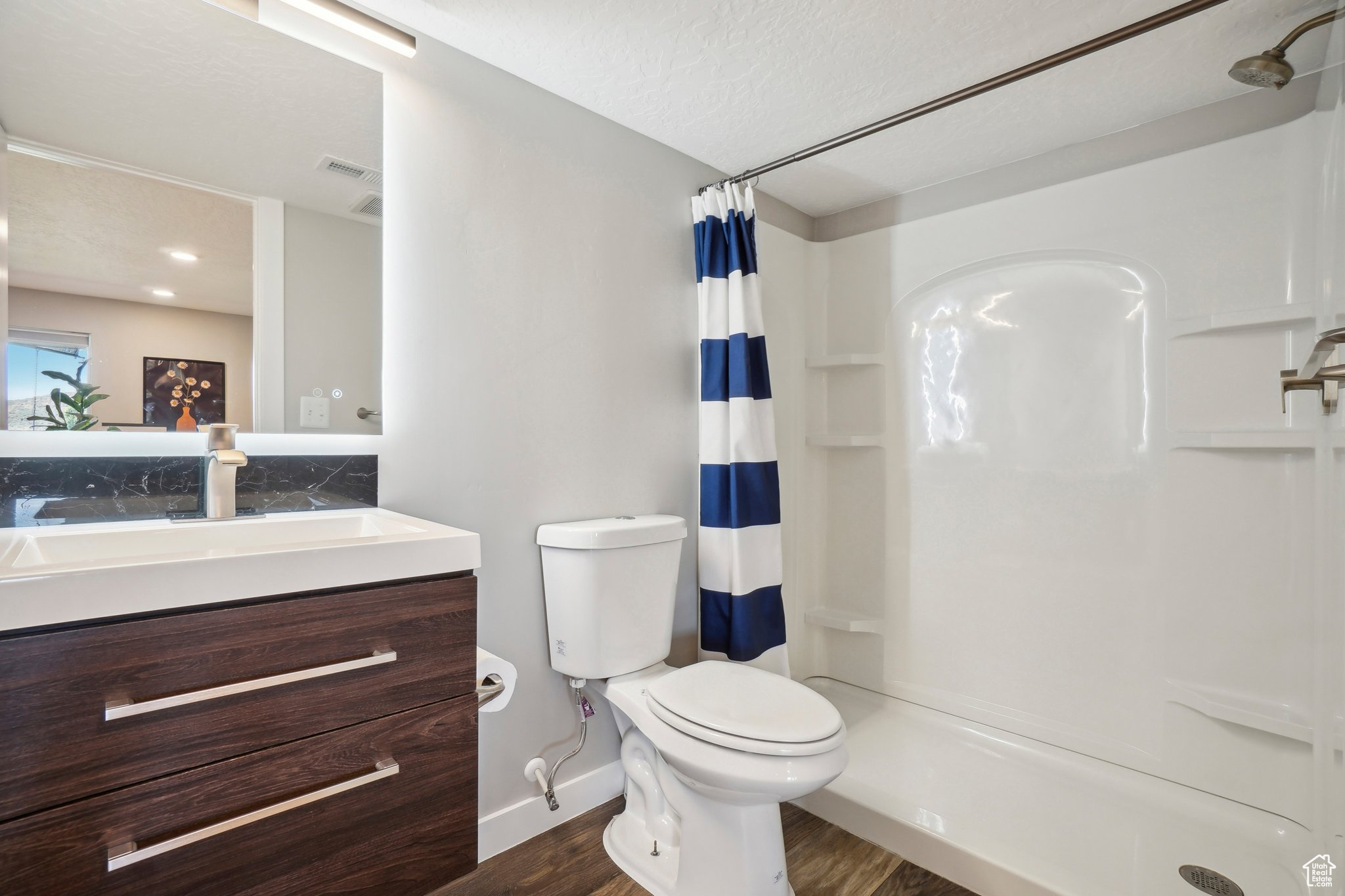 Bathroom with toilet, vanity, hardwood / wood-style flooring, and a textured ceiling