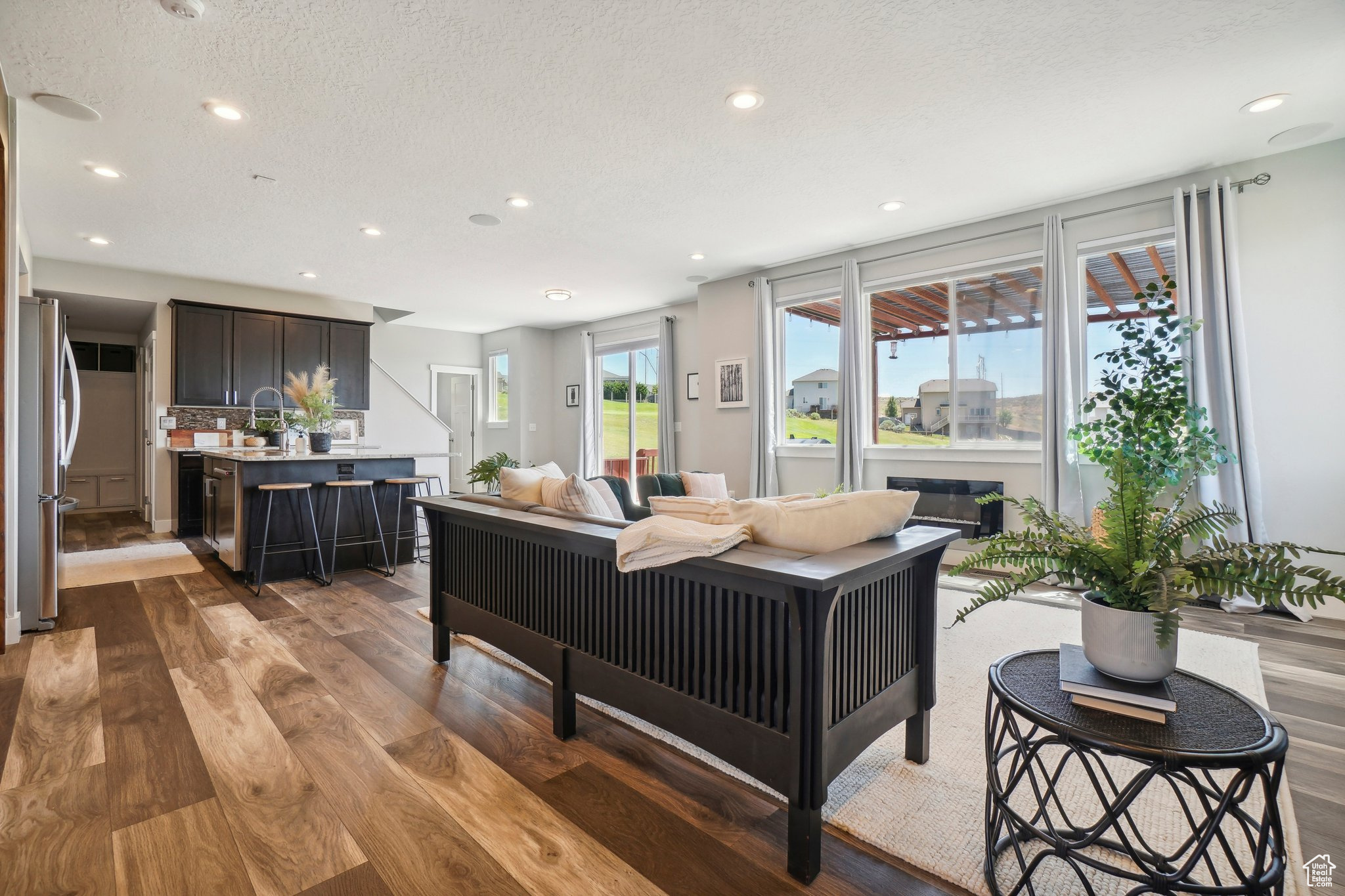 Living room featuring wood-type flooring, sink, and a textured ceiling