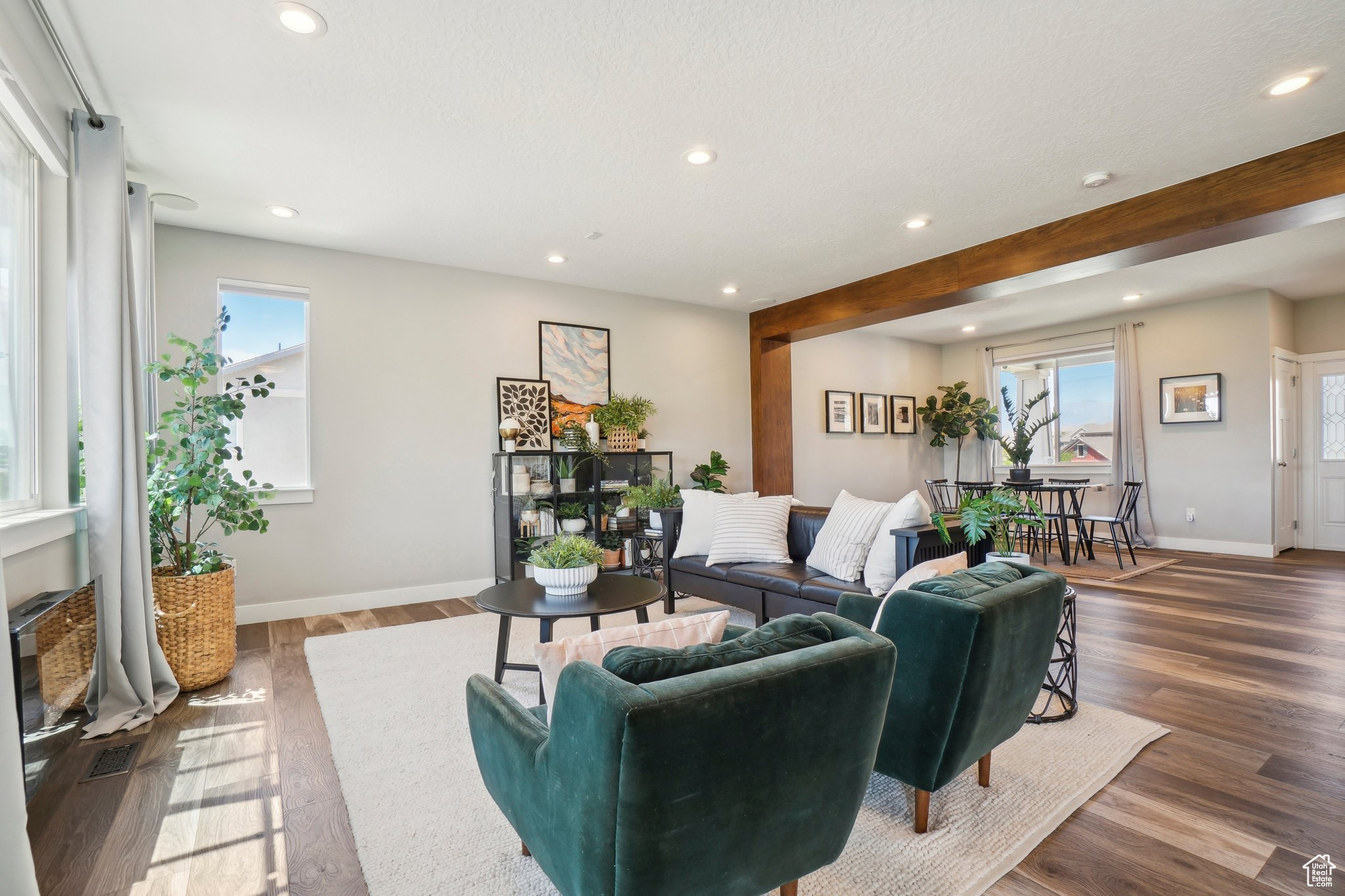 Living room with beamed ceiling, a wealth of natural light, and dark wood-type flooring