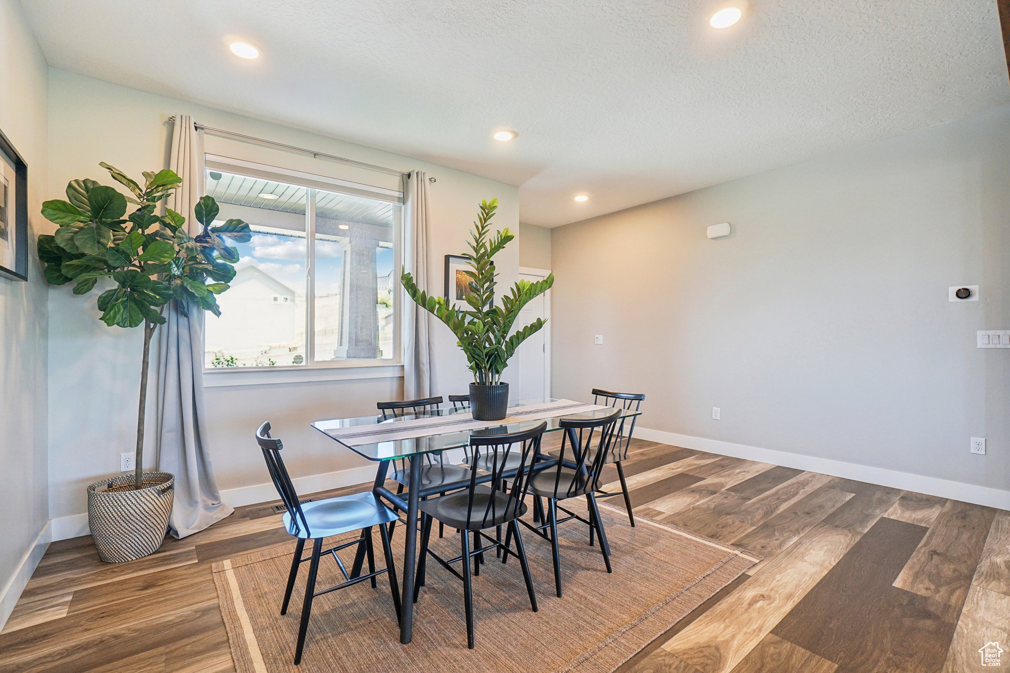 Dining area with hardwood / wood-style floors and a textured ceiling