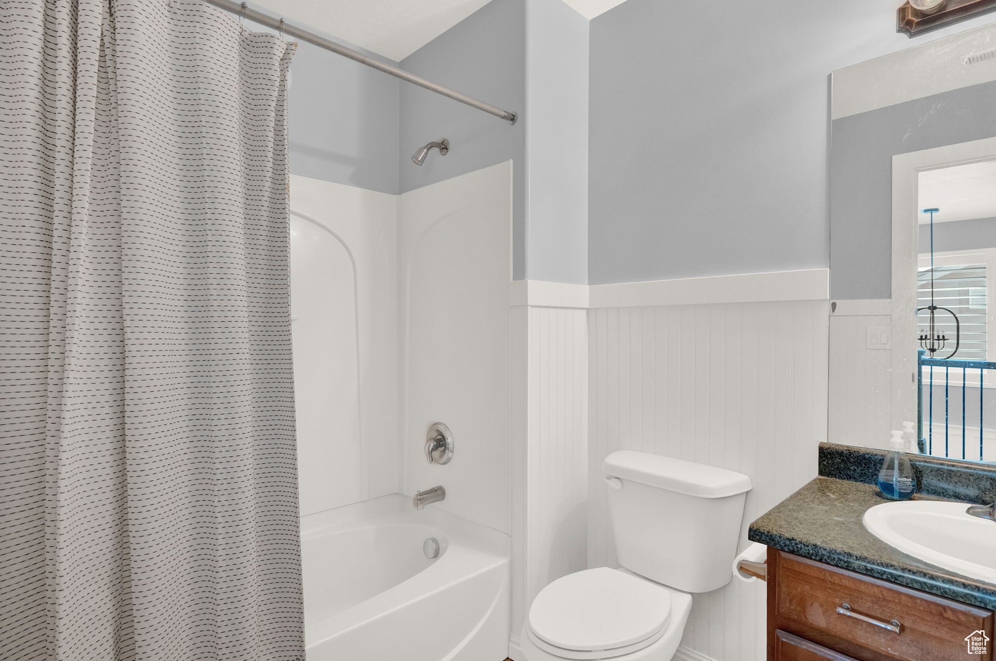 Full bathroom featuring oversized vanity, shower / tub combo, and toilet