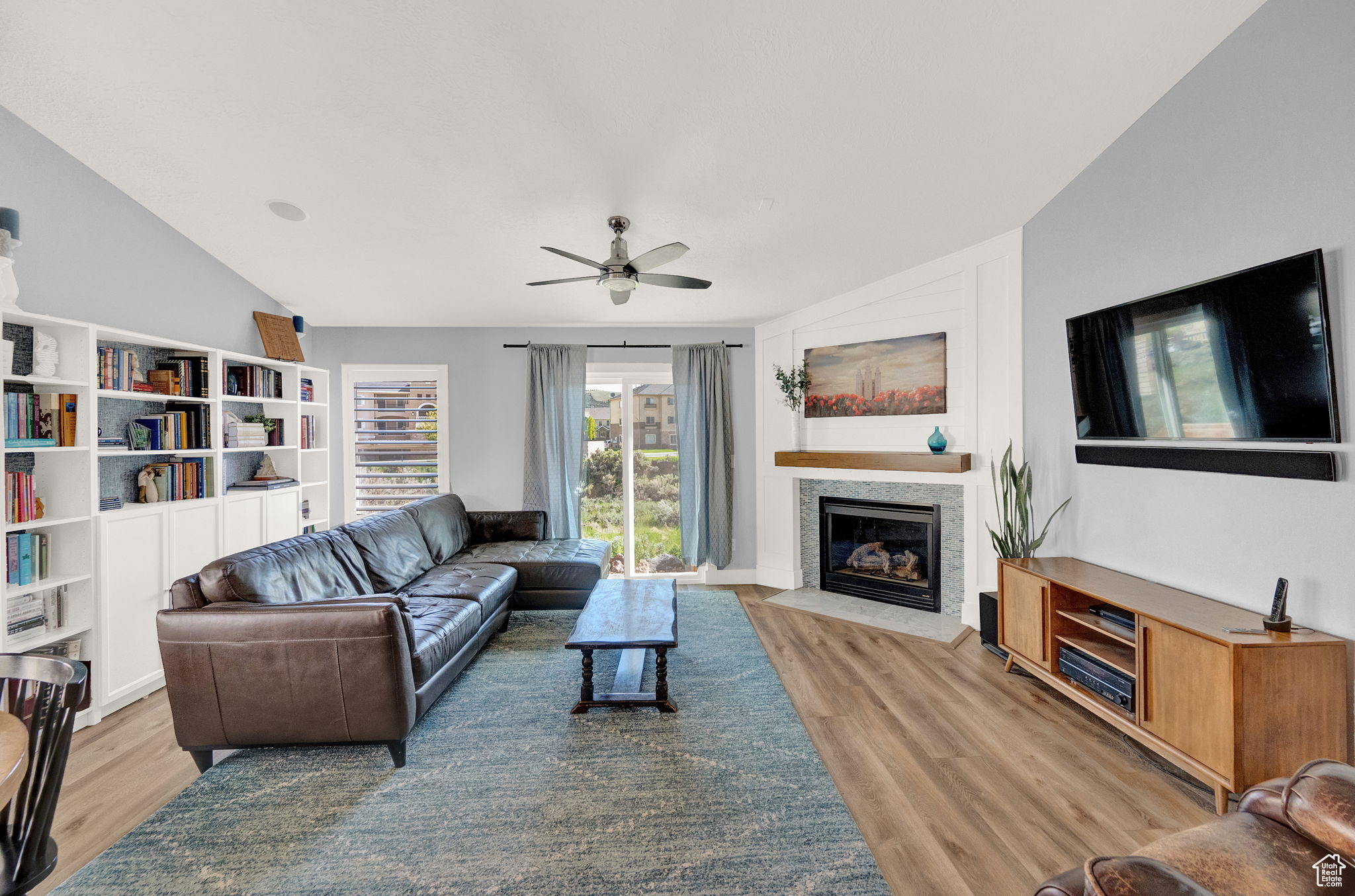 Living room featuring light hardwood / wood-style floors, ceiling fan, and lofted ceiling