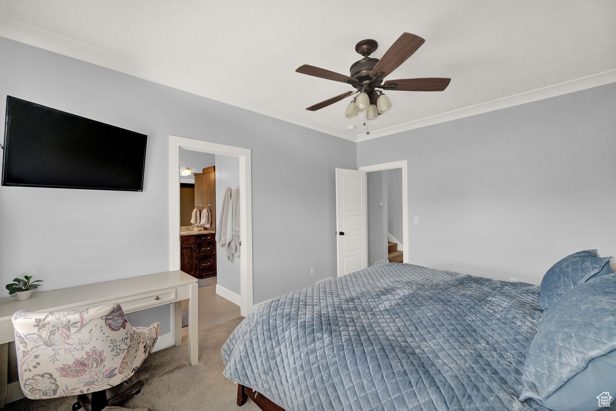 Carpeted bedroom with crown molding, ceiling fan, and ensuite bathroom