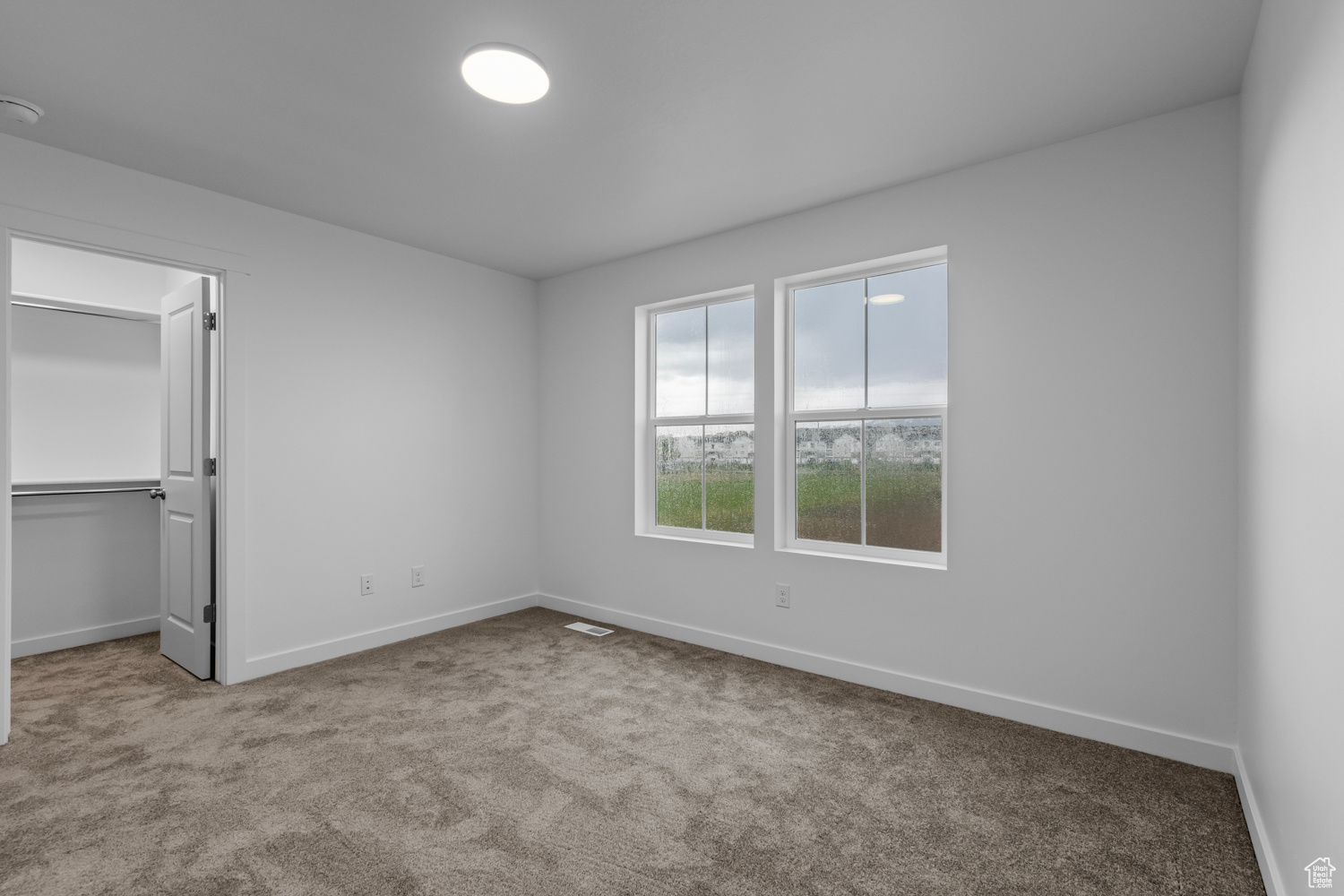 Unfurnished bedroom featuring carpet and a spacious closet