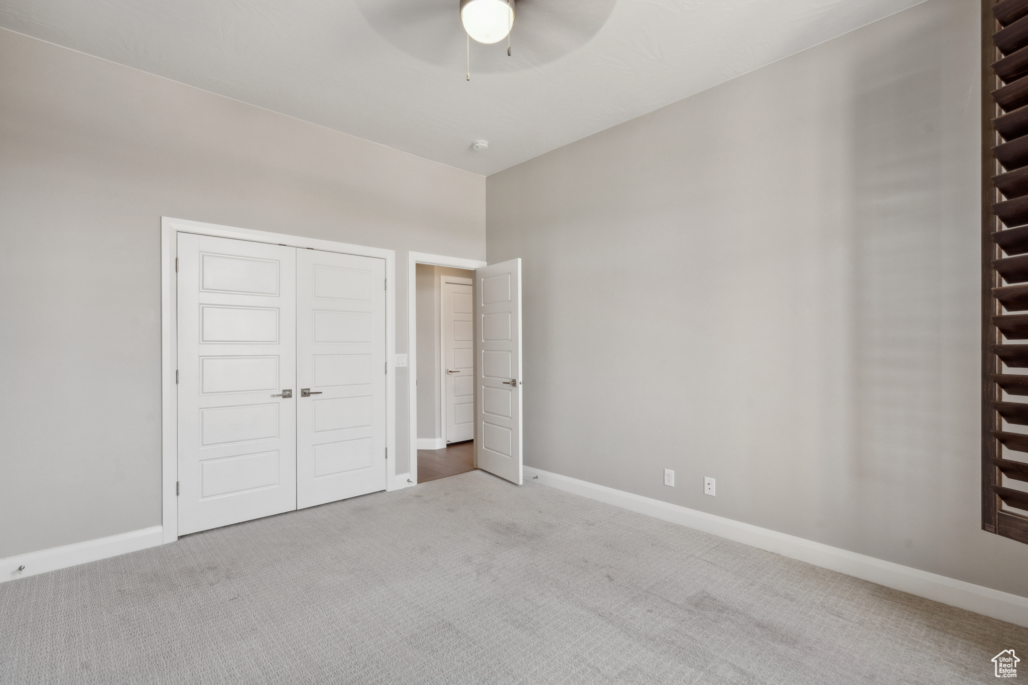 Unfurnished bedroom featuring ceiling fan and carpet floors
