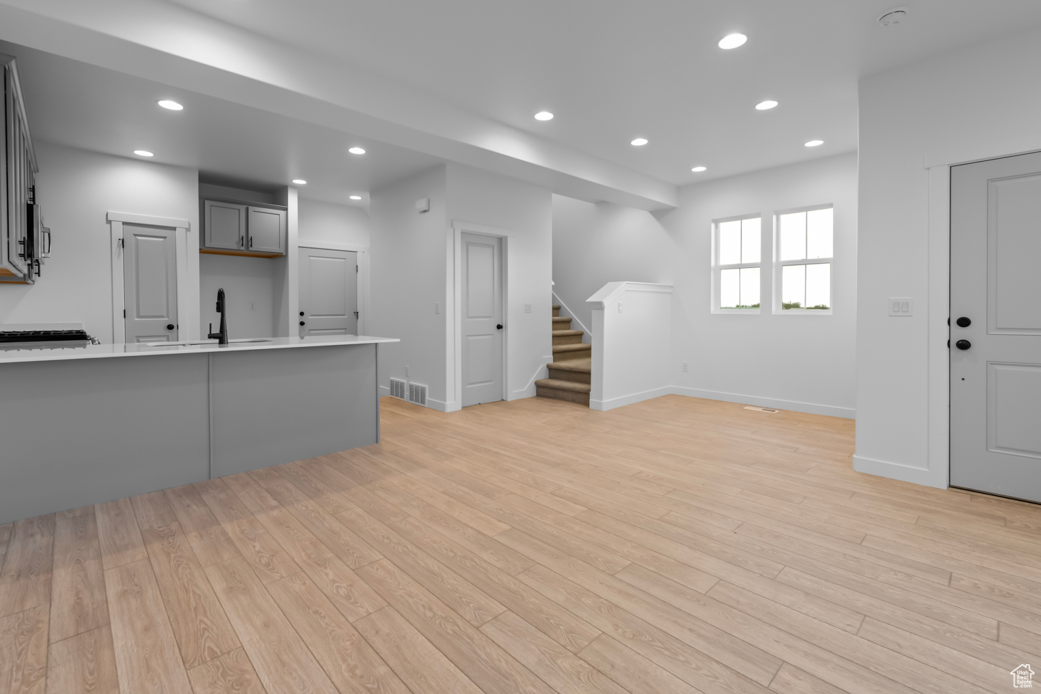 Kitchen with gray cabinets, sink, and light hardwood / wood-style floors