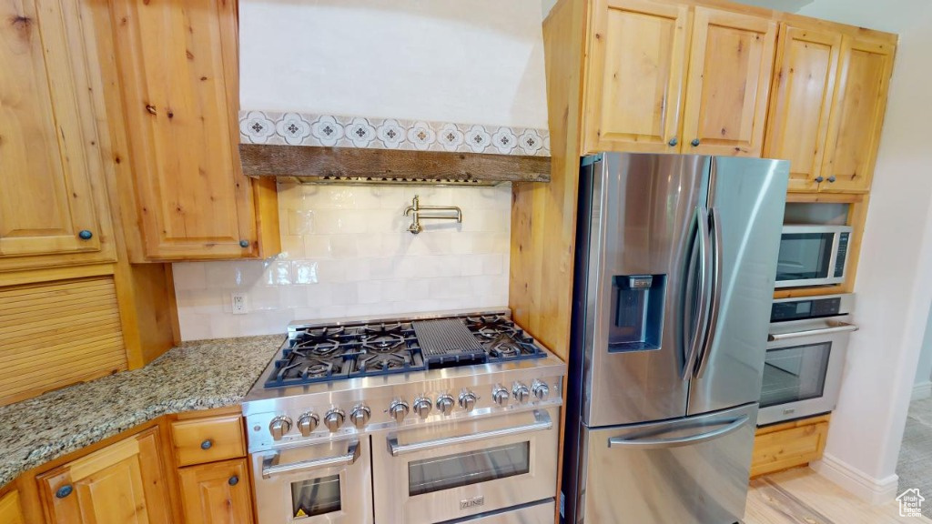 Beautiful chef's kitchen with a large and high-end range and stainless steel appliances