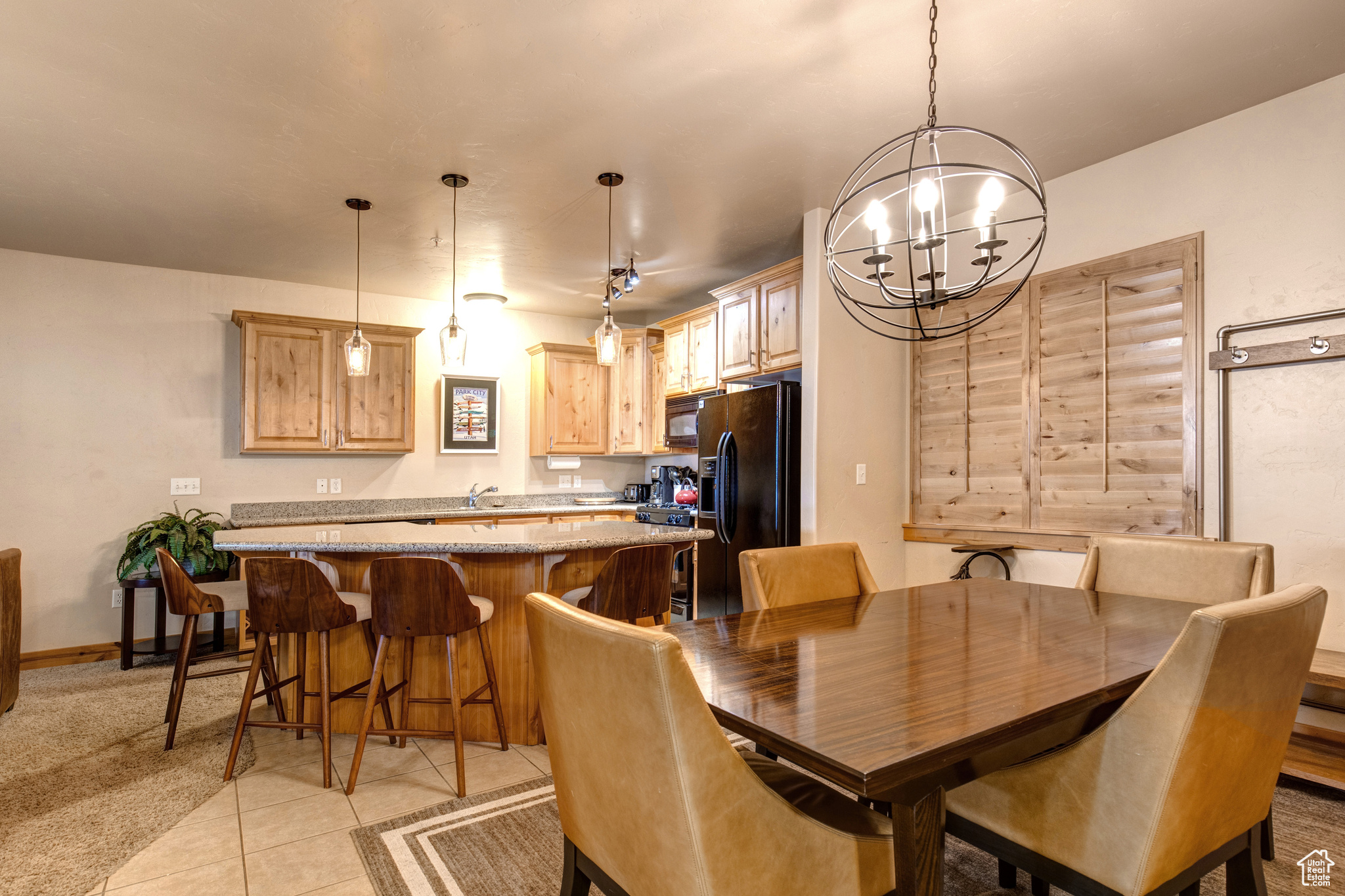 Dining space with sink, a chandelier, and light tile floors