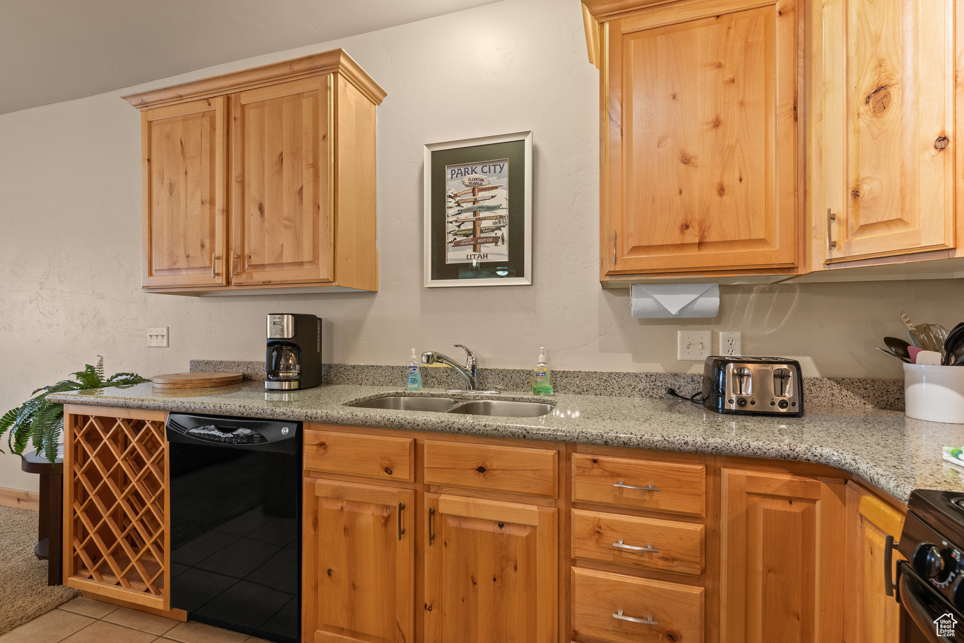 Kitchen featuring range with electric stovetop, dishwasher, light tile floors, and sink