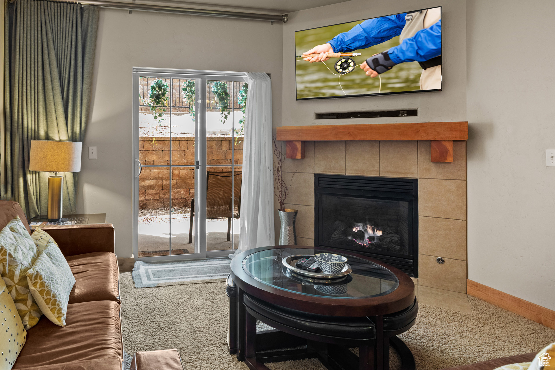 Carpeted living room featuring a tiled fireplace