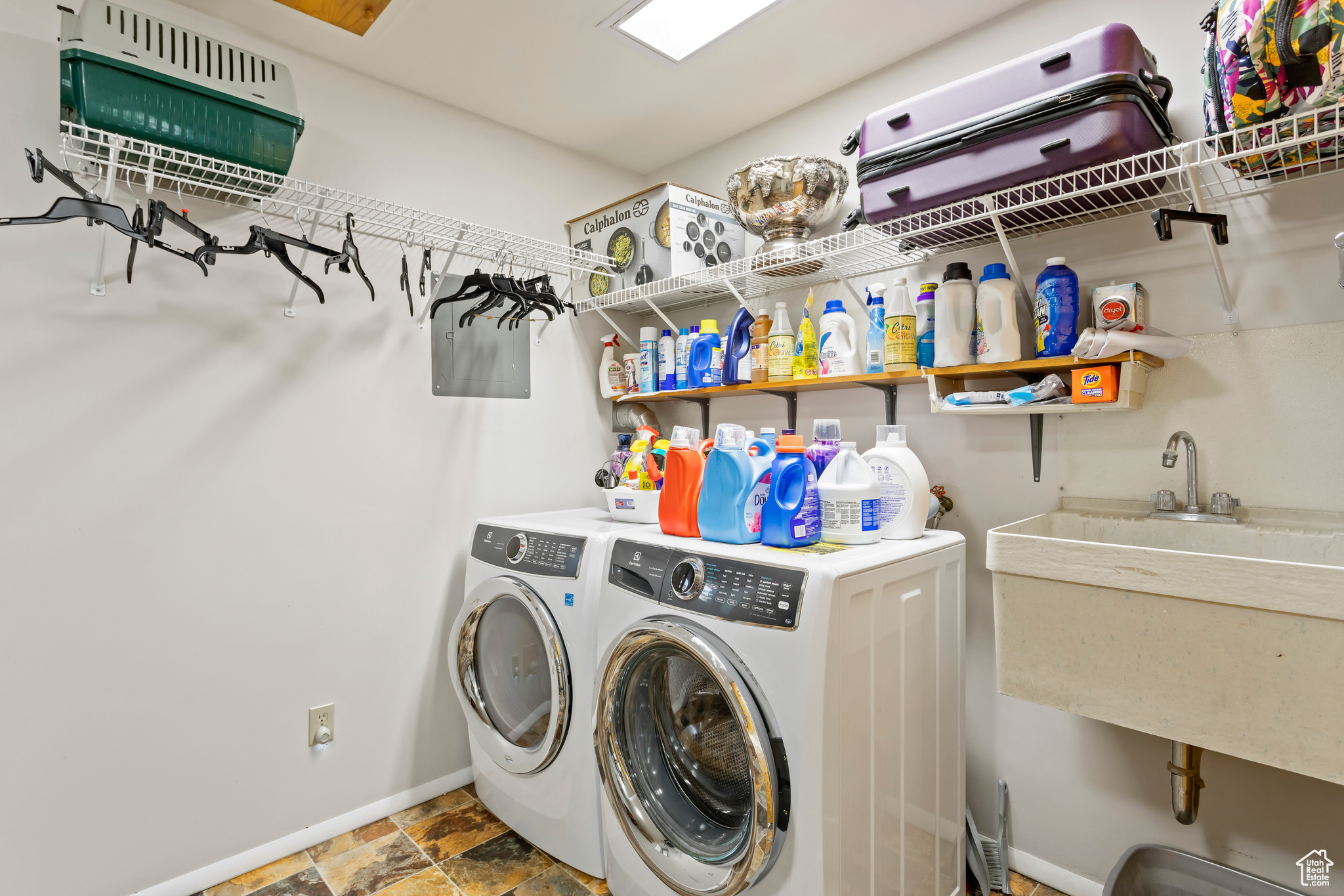 Clothes washing area featuring tile flooring and washer and dryer