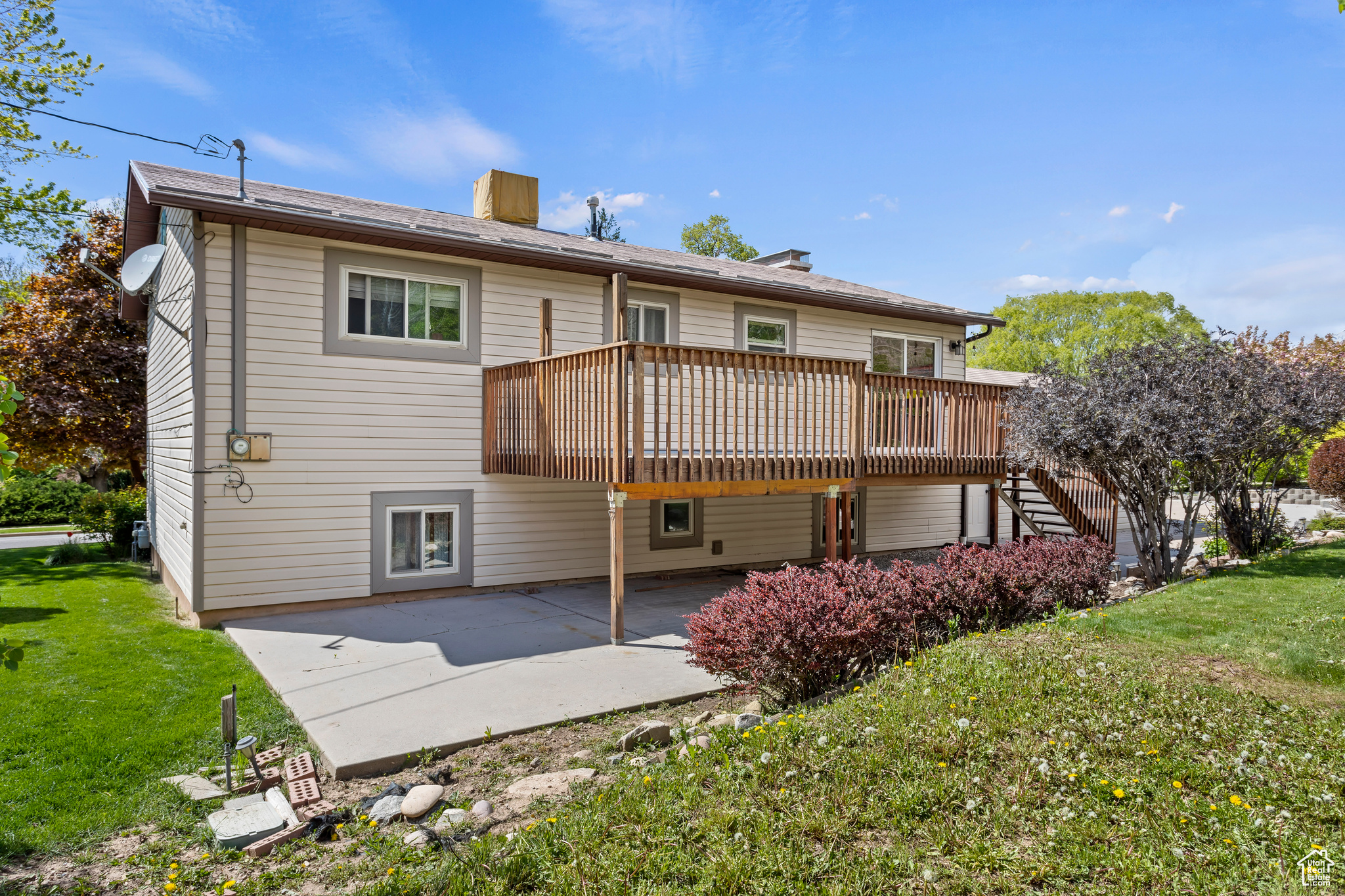 Back of property featuring a patio, a yard, and a deck