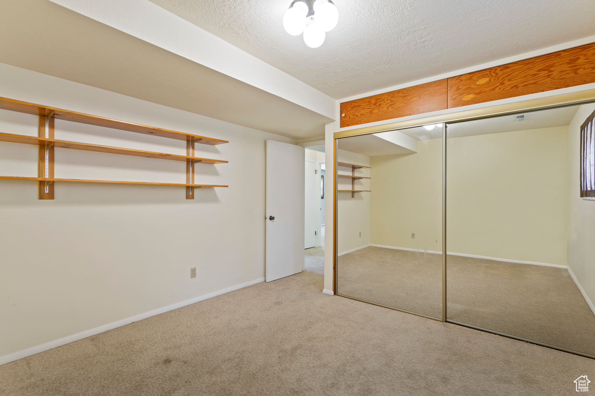 Unfurnished bedroom featuring a closet, a textured ceiling, and carpet flooring