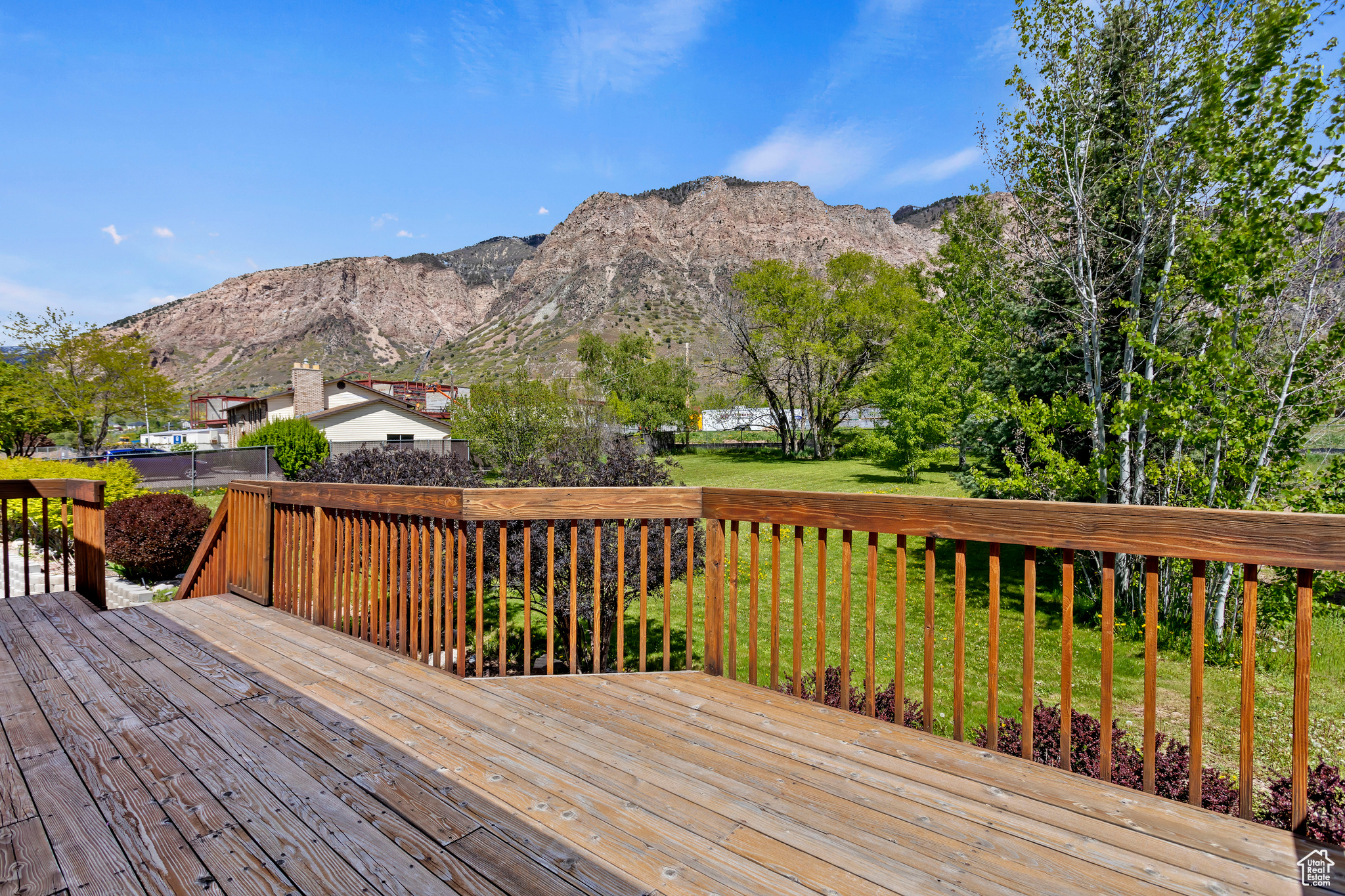 Wooden terrace featuring a mountain view and a yard