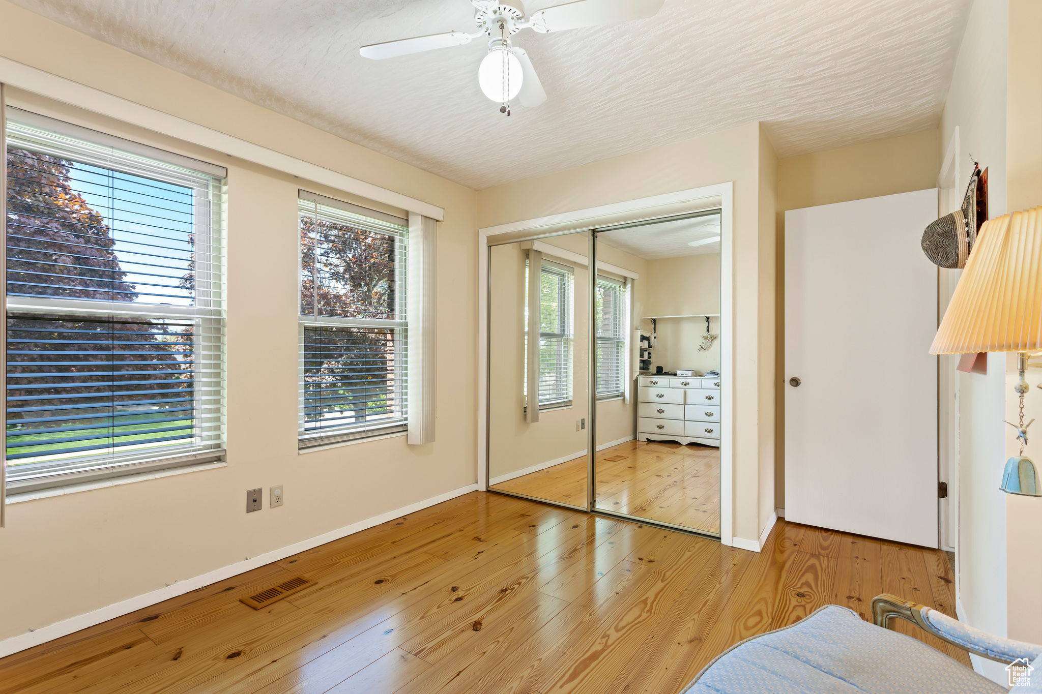 Bedroom featuring ceiling fan, a closet, and light wood-type flooring