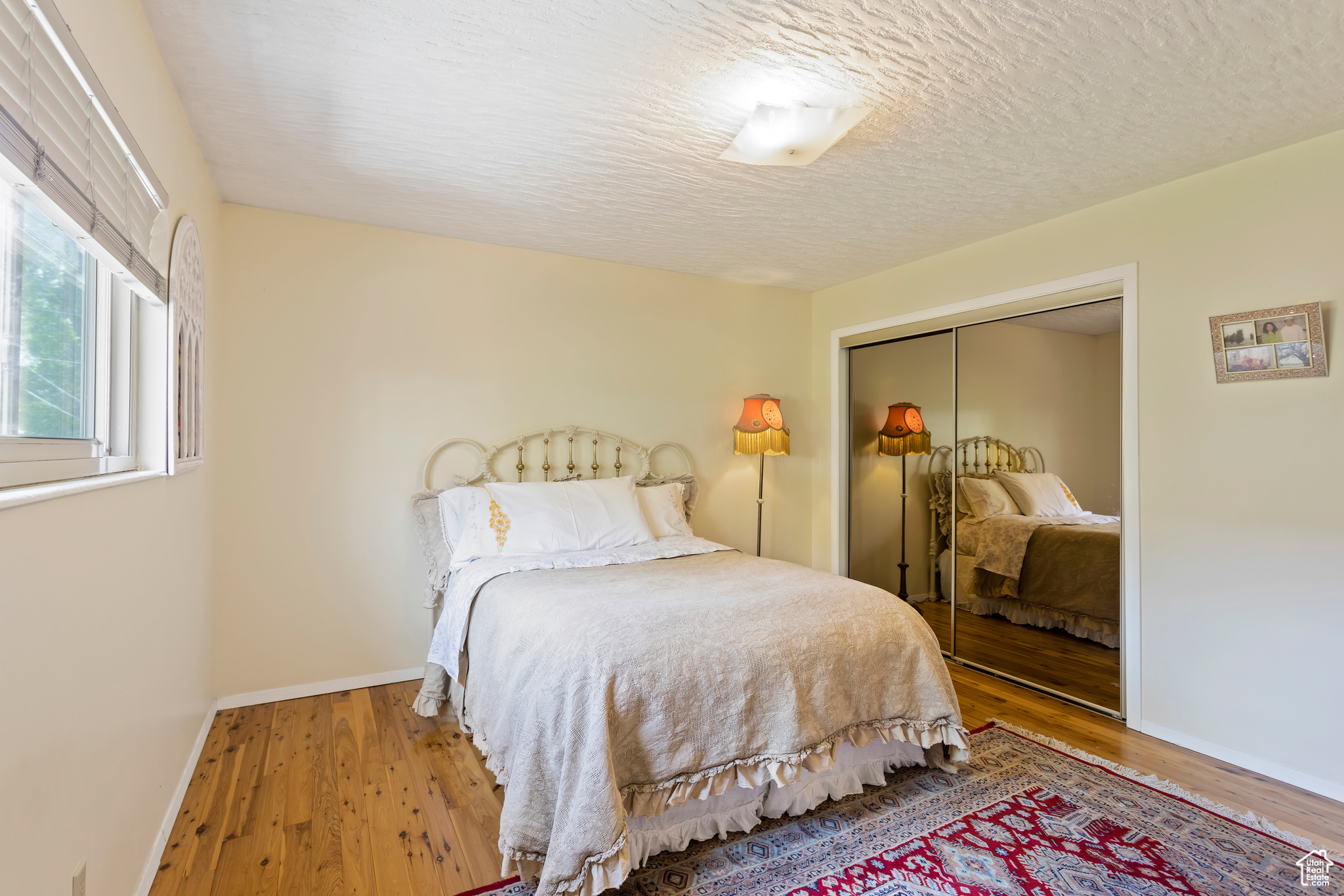 Bedroom with a closet, hardwood / wood-style flooring, and a textured ceiling