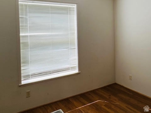 Unfurnished room featuring dark hardwood / wood-style floors