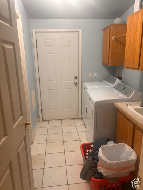 Washroom featuring light tile patterned floors, independent washer and dryer, and cabinets