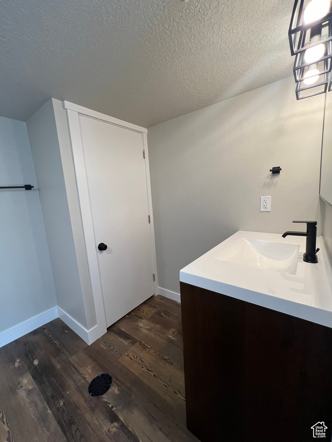 Bathroom featuring vanity, hardwood / wood-style flooring, and a textured ceiling