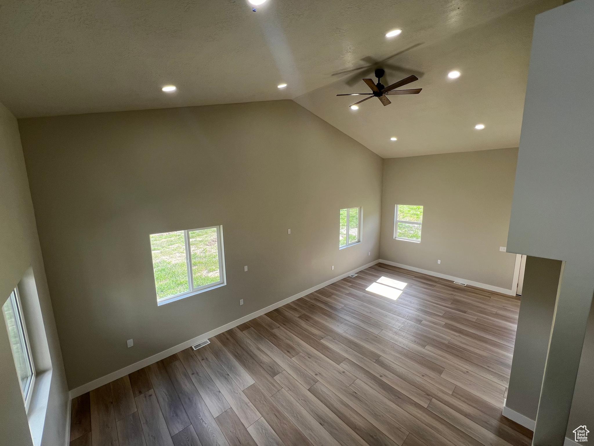 Unfurnished room with light hardwood / wood-style flooring, ceiling fan, and plenty of natural light