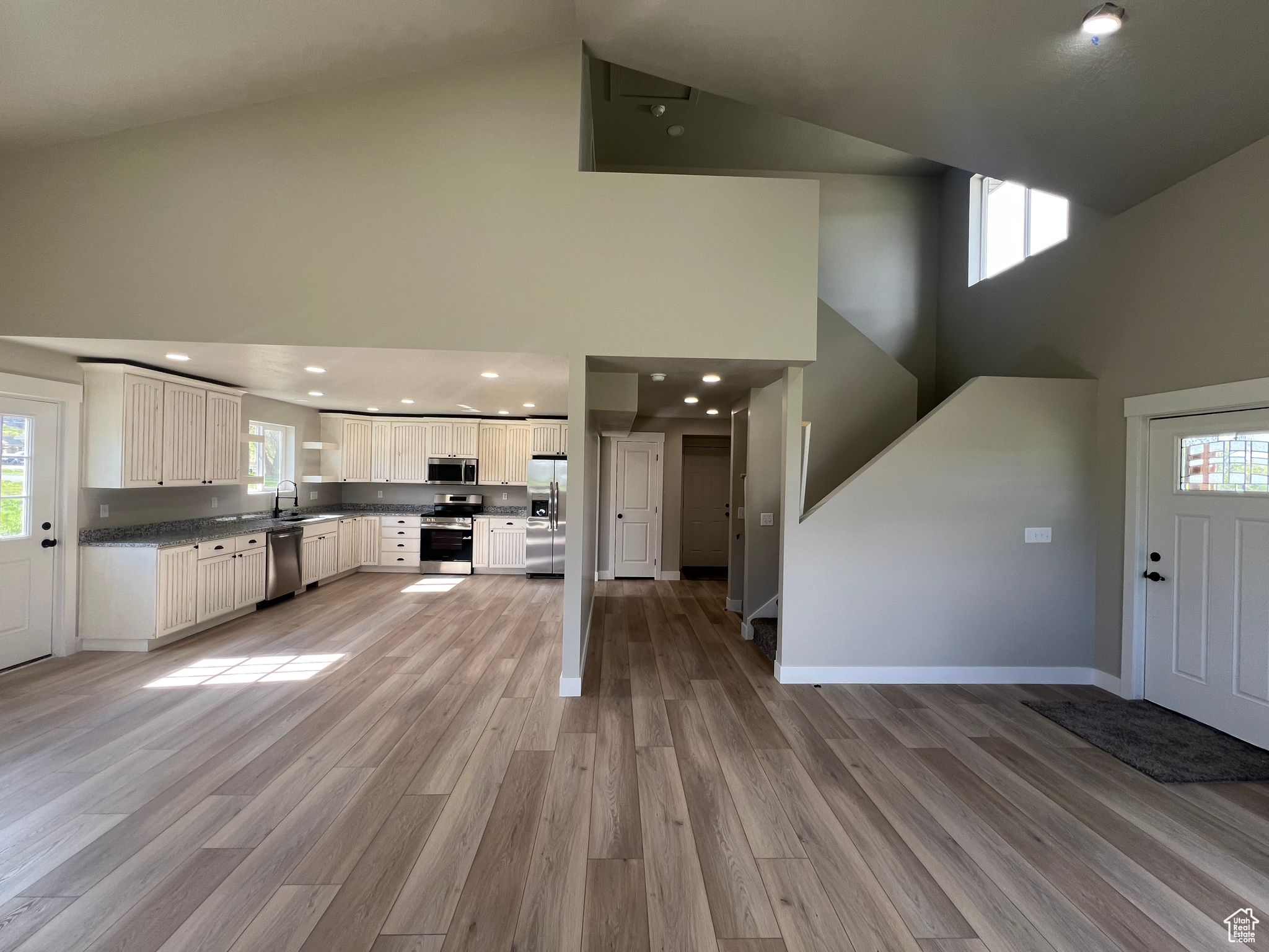 Interior space with hardwood / wood-style flooring, high vaulted ceiling, and sink