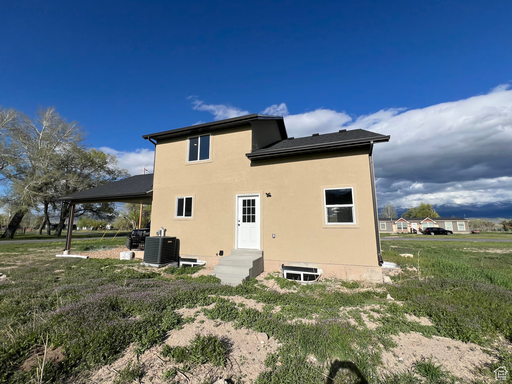 Rear view of property with a yard and central air condition unit