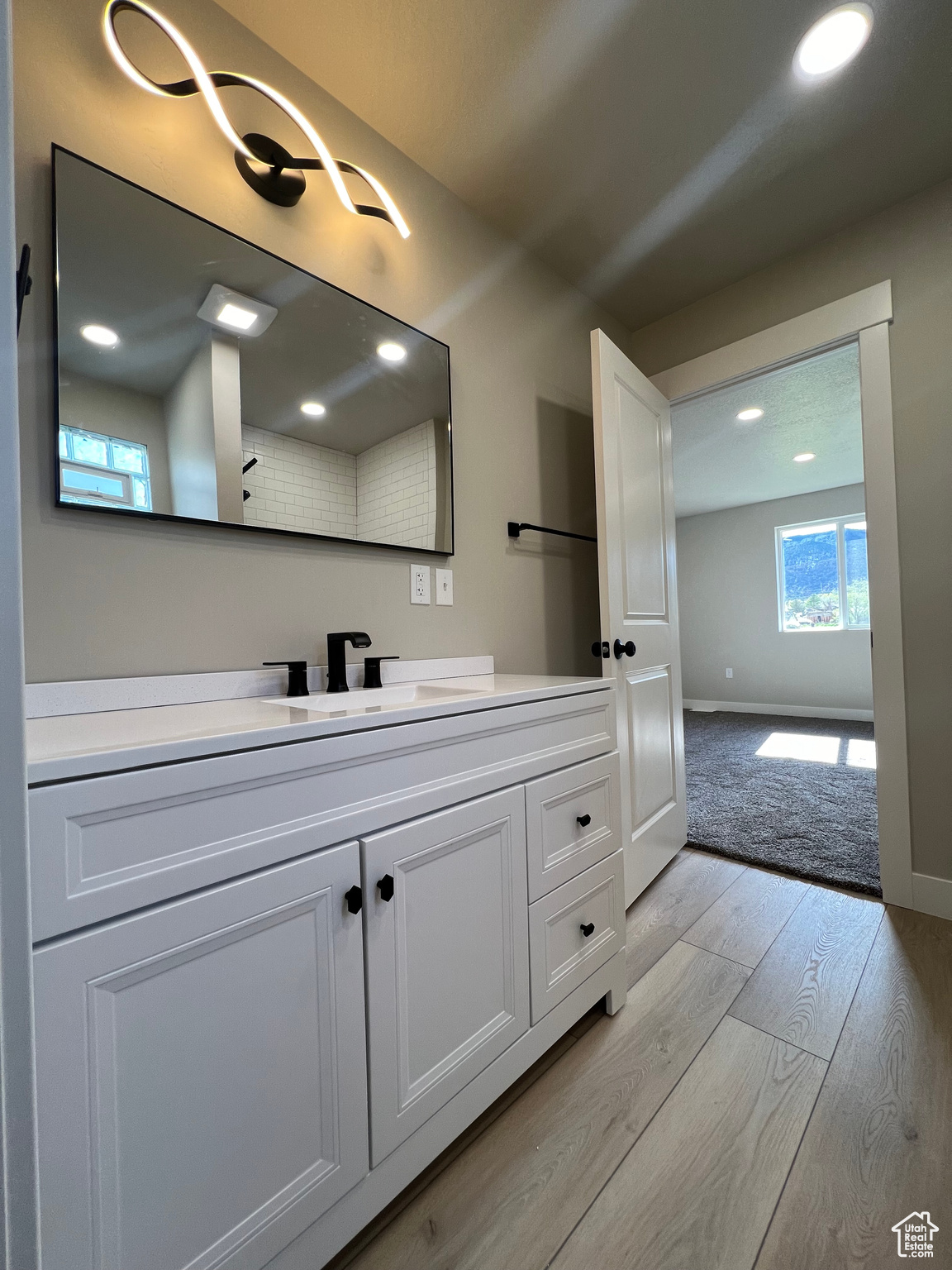 Bathroom featuring vanity with extensive cabinet space and hardwood / wood-style flooring