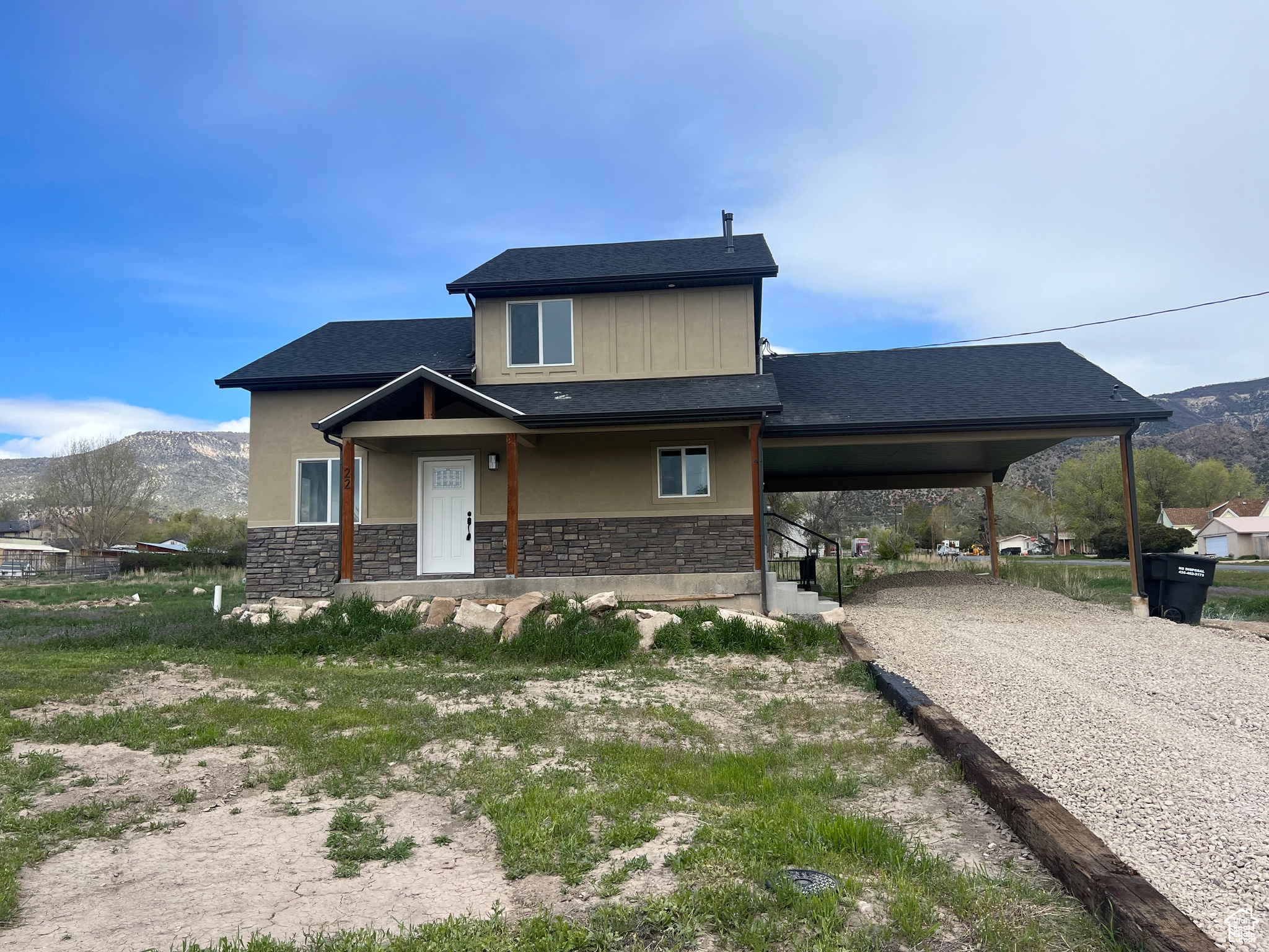 View of front of home with a mountain view and a carport