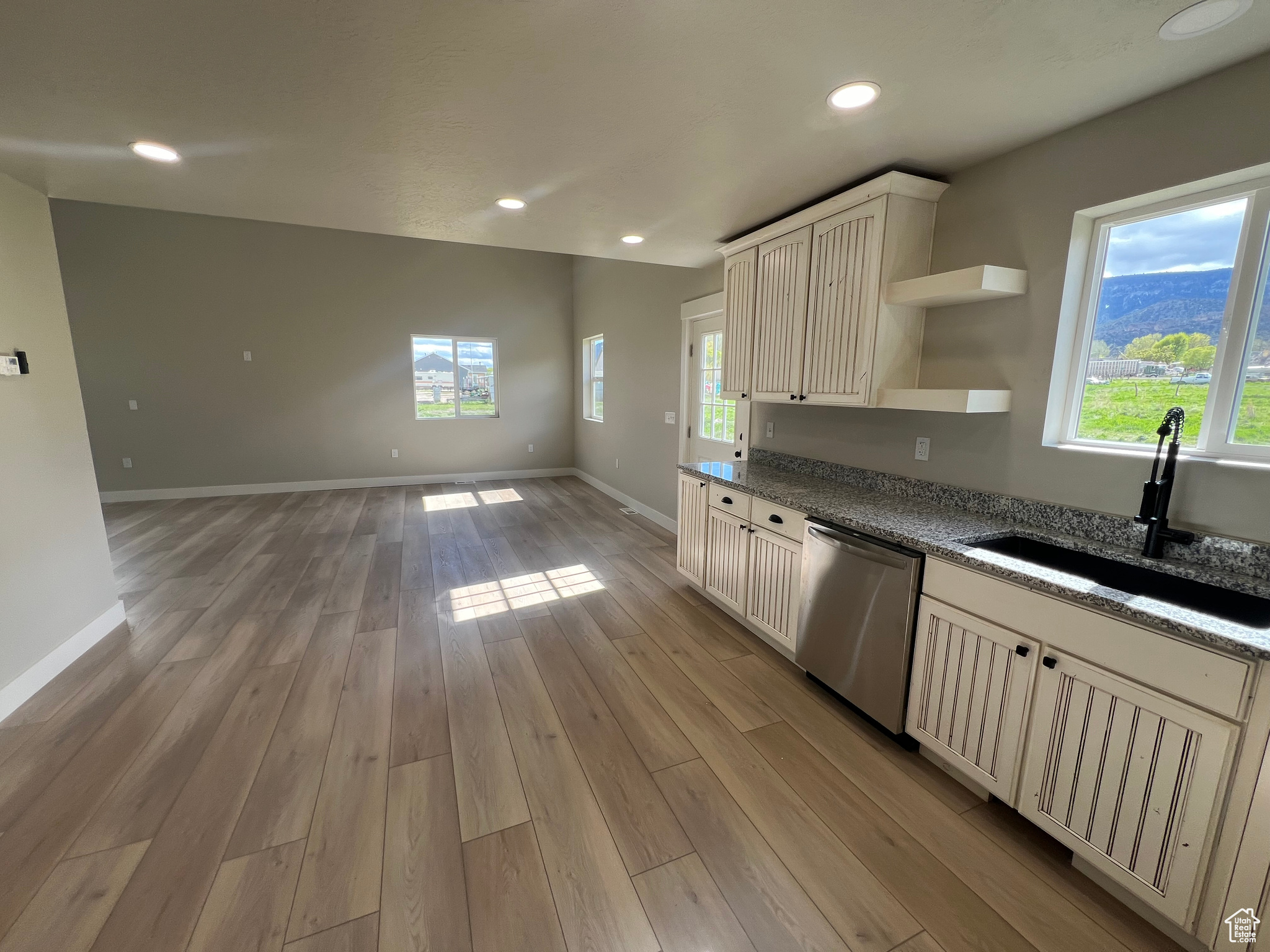 Kitchen with wood-type flooring, dishwasher, a healthy amount of sunlight, and sink