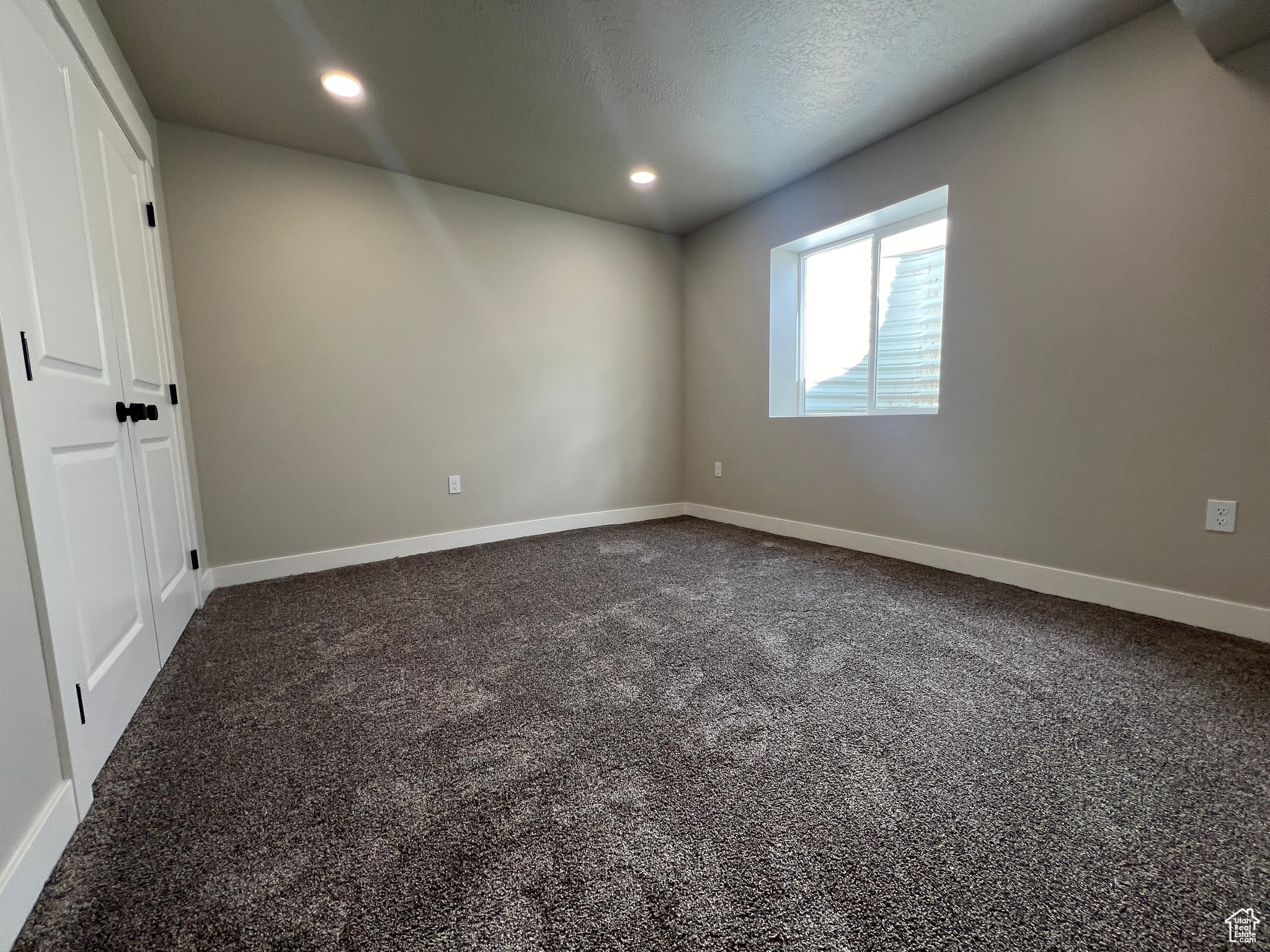 Carpeted spare room with a textured ceiling