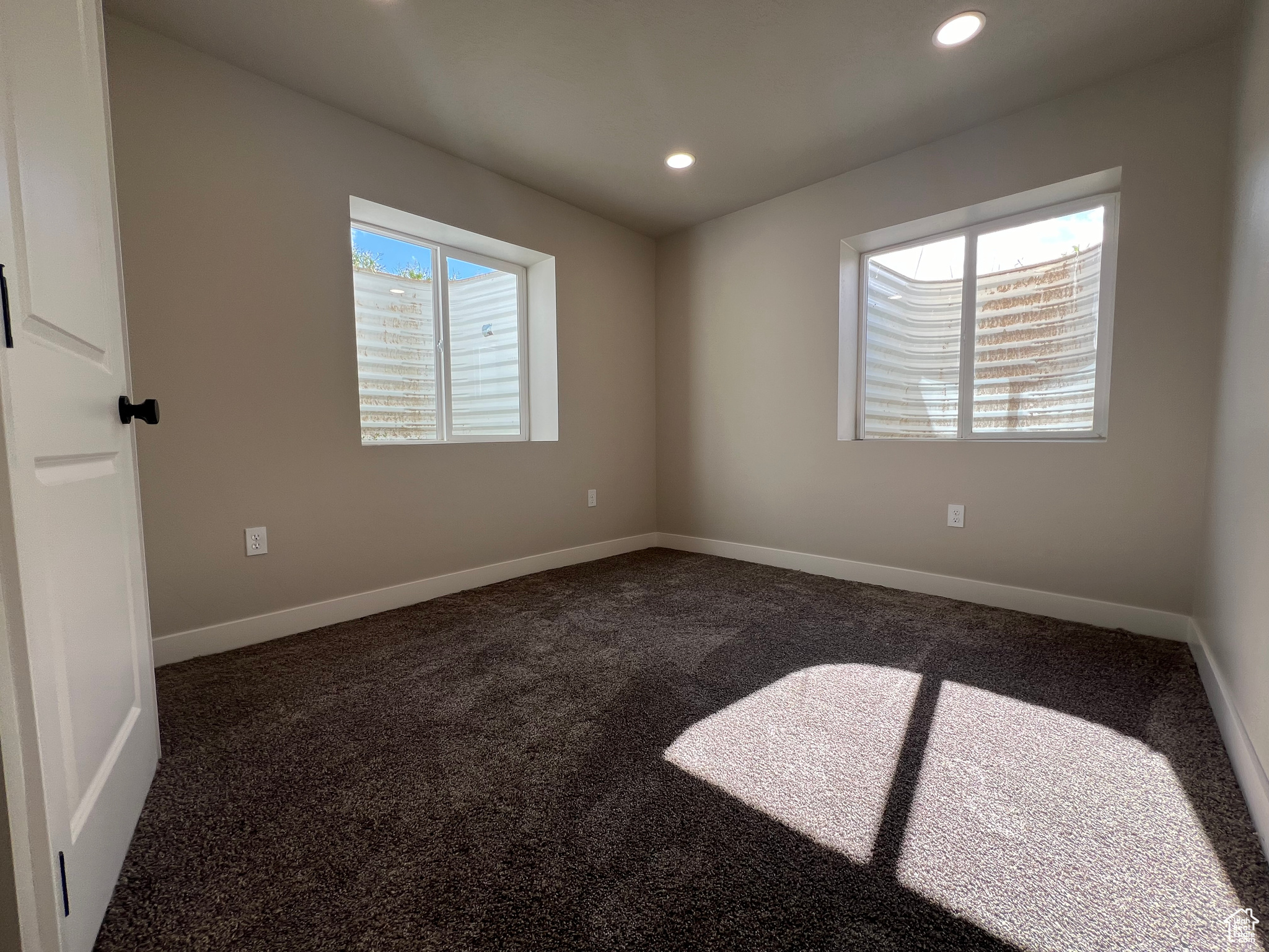 Spare room with plenty of natural light and dark carpet