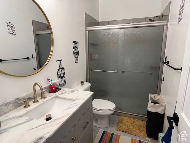 Bathroom with tile flooring, walk in shower, vanity, and toilet