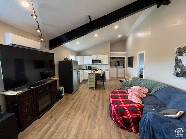 Living room featuring independent washer and dryer, light hardwood / wood-style flooring, an AC wall unit, high vaulted ceiling, and beamed ceiling