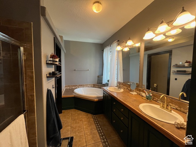 Bathroom with large vanity, tile flooring, double sink, and plus walk in shower