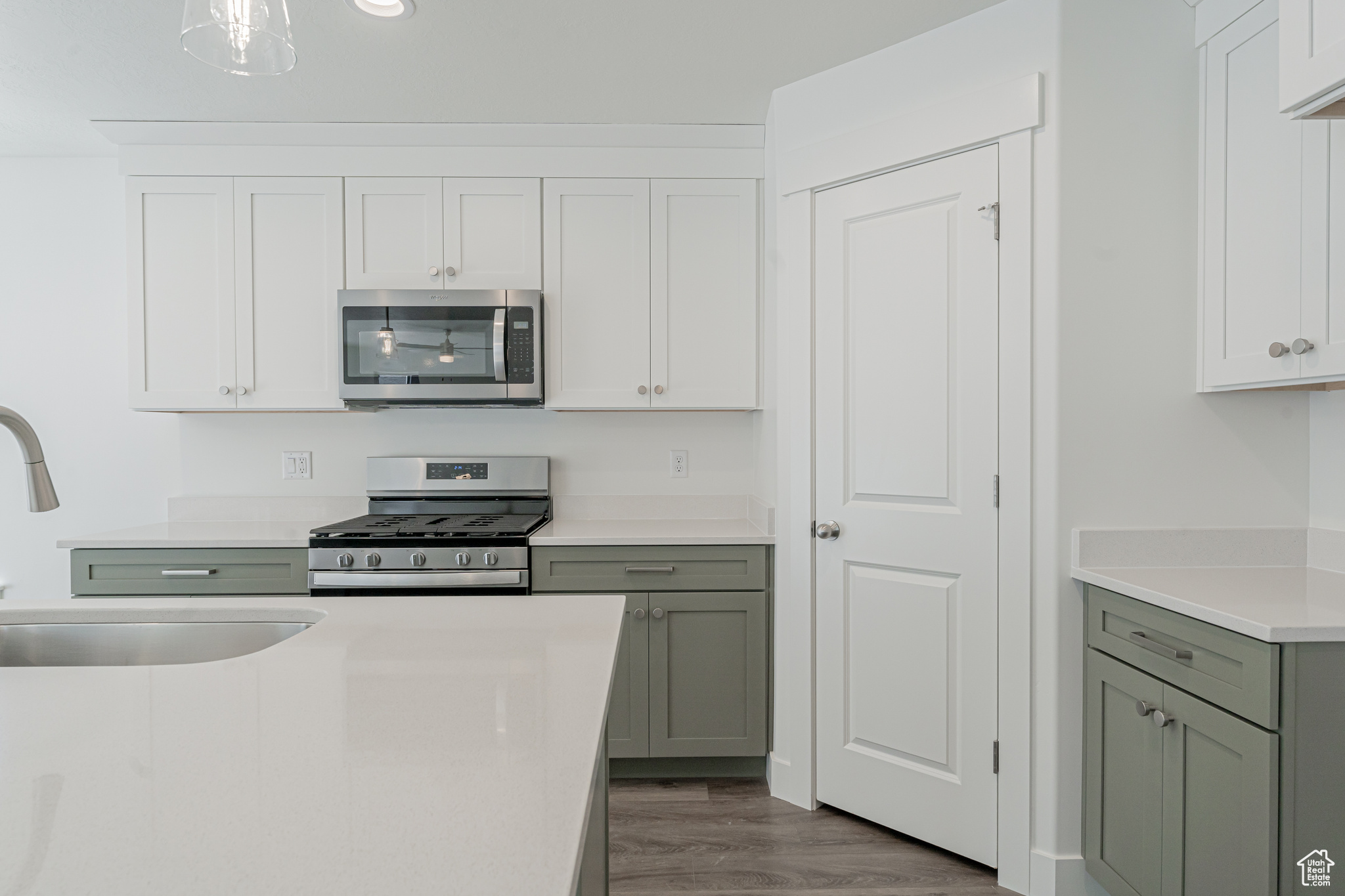 Kitchen with hardwood / wood-style floors, stainless steel appliances, and sink