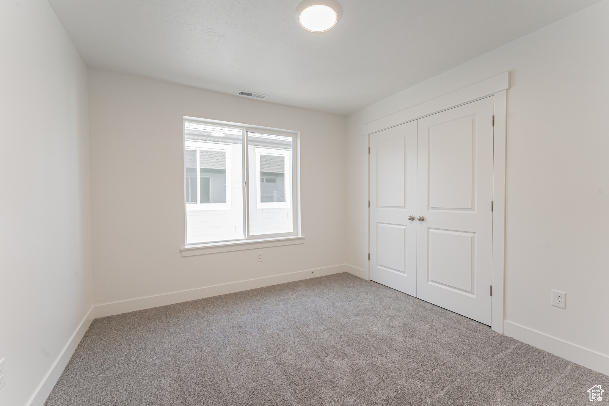 Unfurnished bedroom featuring a closet and carpet floors