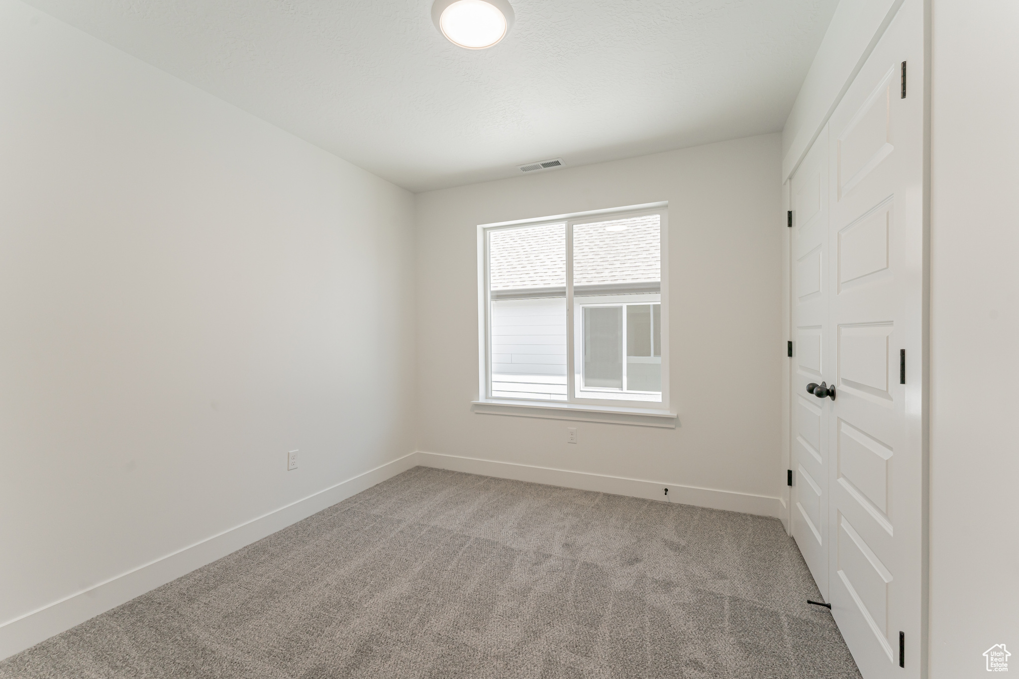 Unfurnished bedroom with light colored carpet