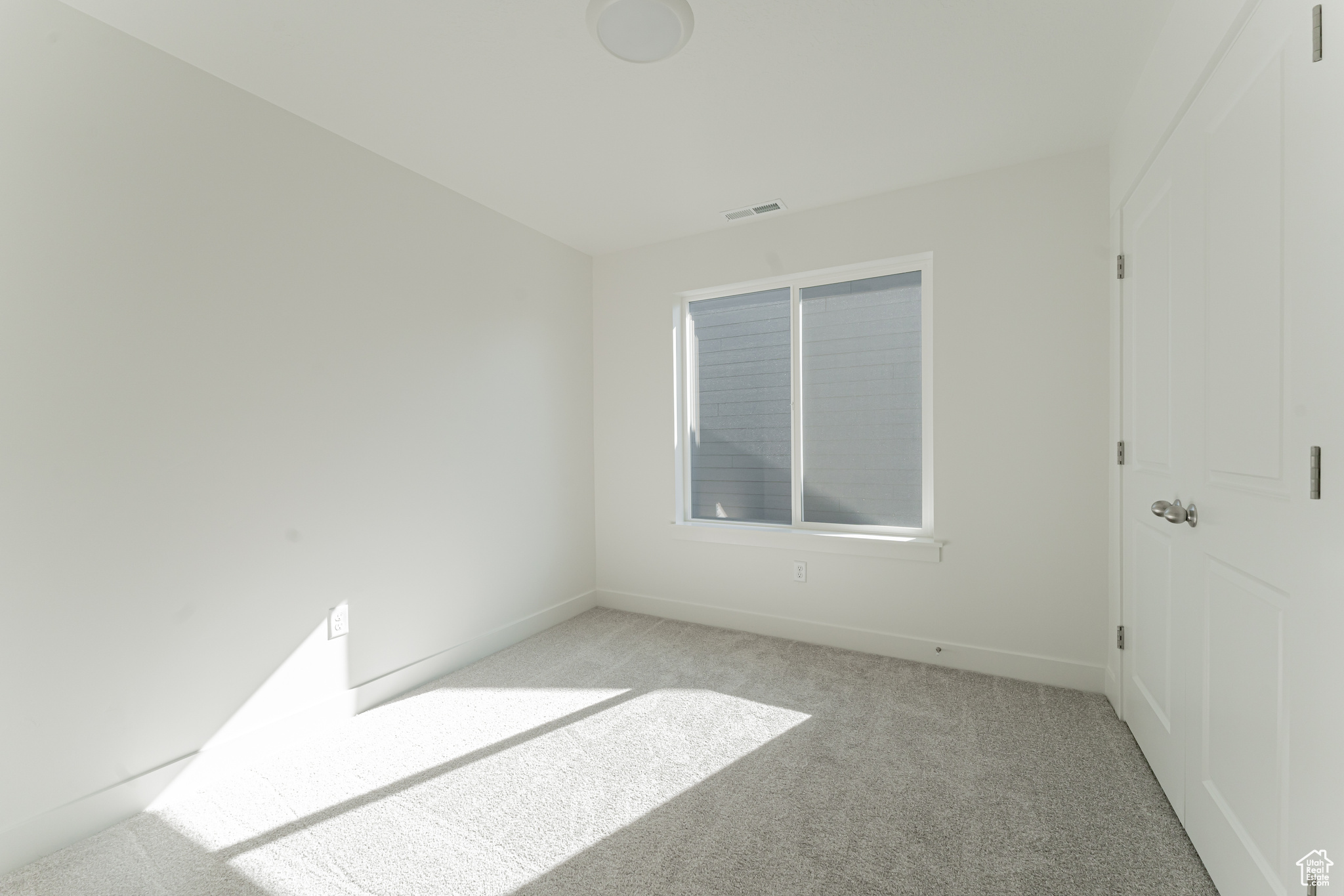 Unfurnished room featuring light carpet