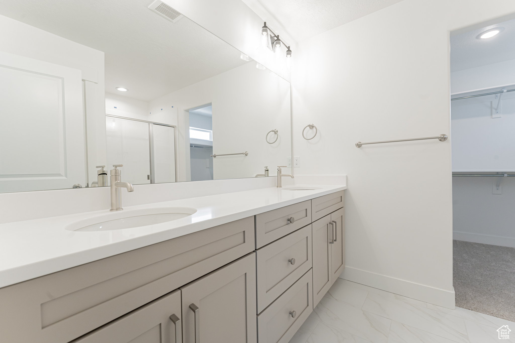 Bathroom with a shower with door, tile patterned floors, and vanity