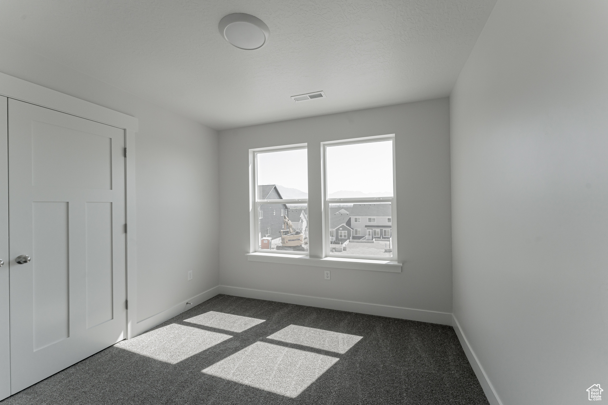 Unfurnished room featuring dark carpet