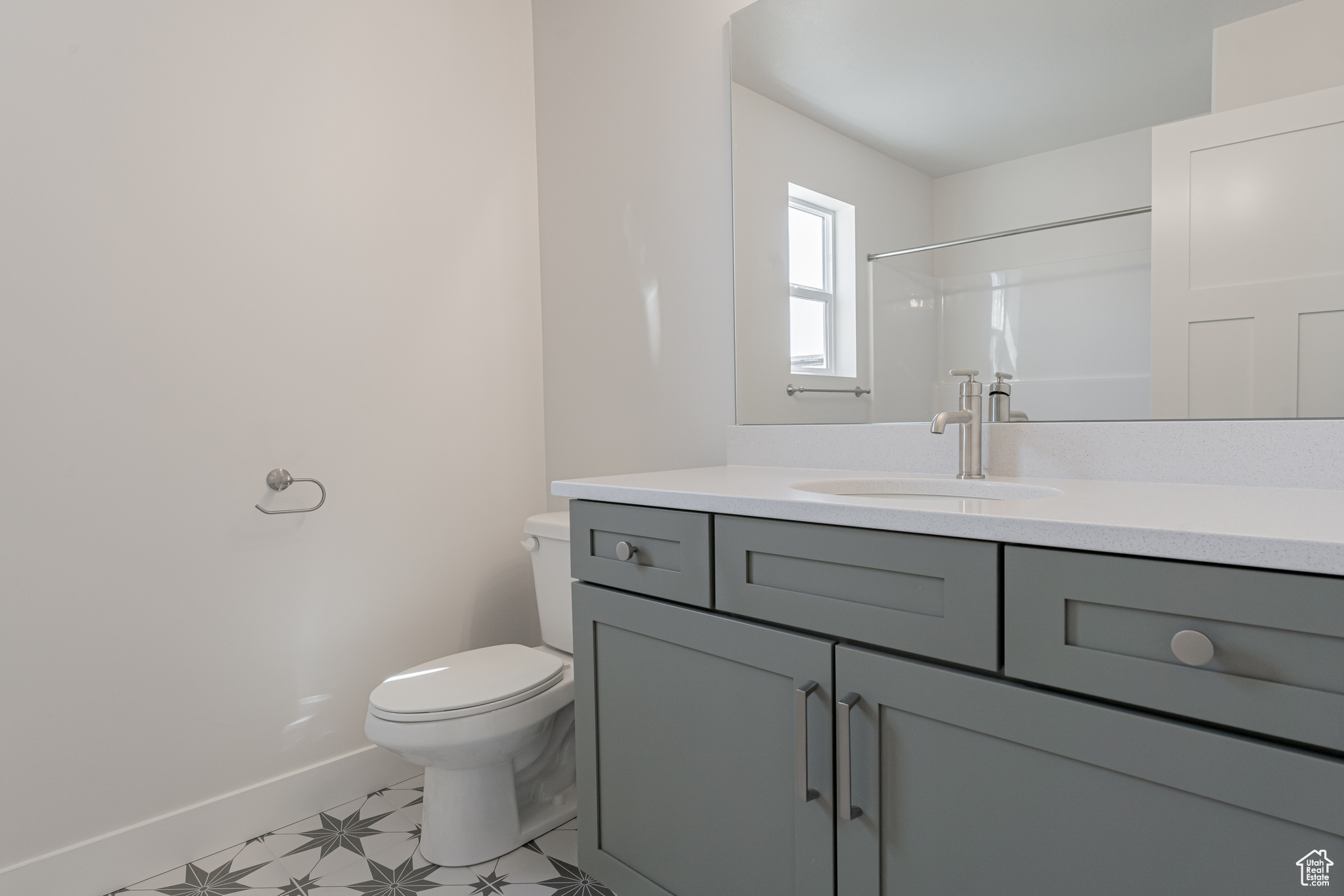 Bathroom featuring vanity, toilet, and a shower