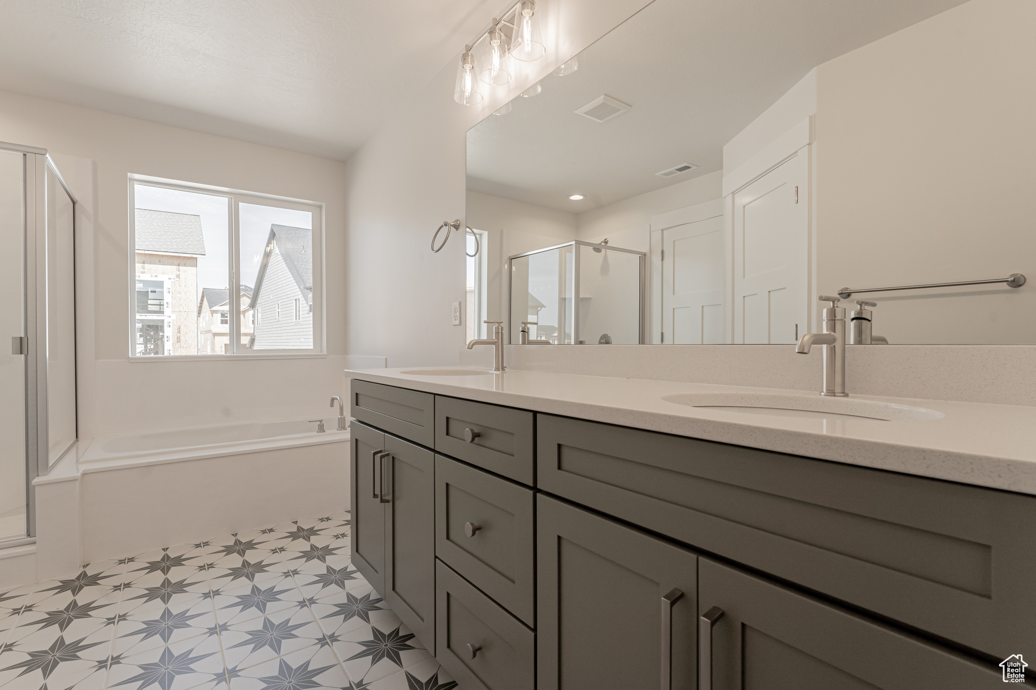 Bathroom featuring vanity and separate shower and tub