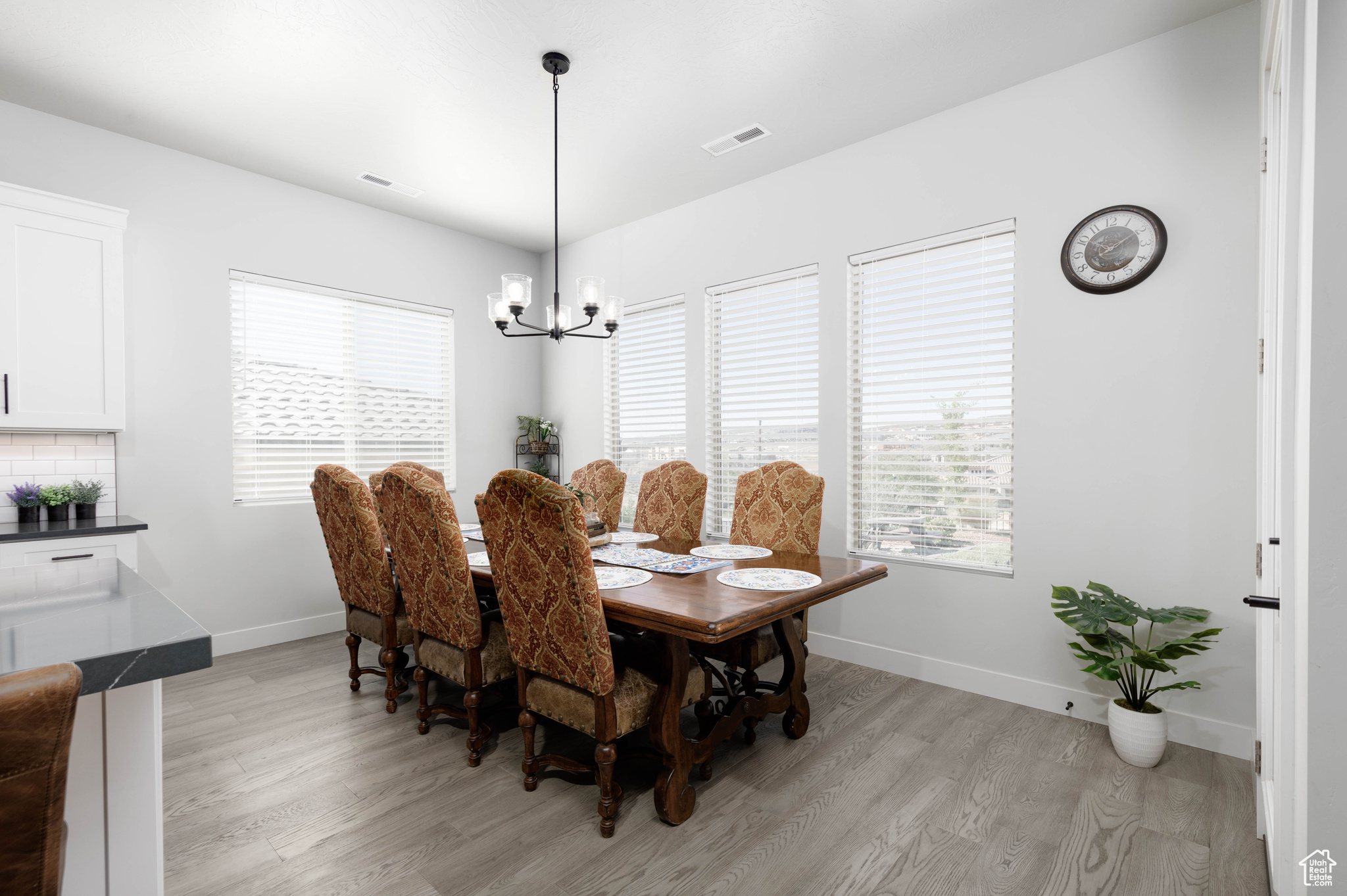 Dining room with light hardwood / wood-style flooring and a notable chandelier