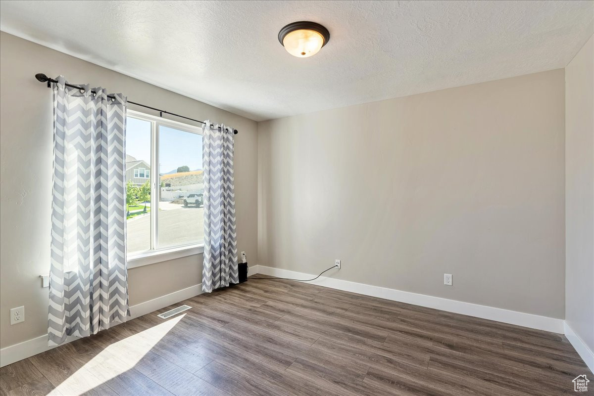 Spare room featuring hardwood / wood-style flooring and a textured ceiling